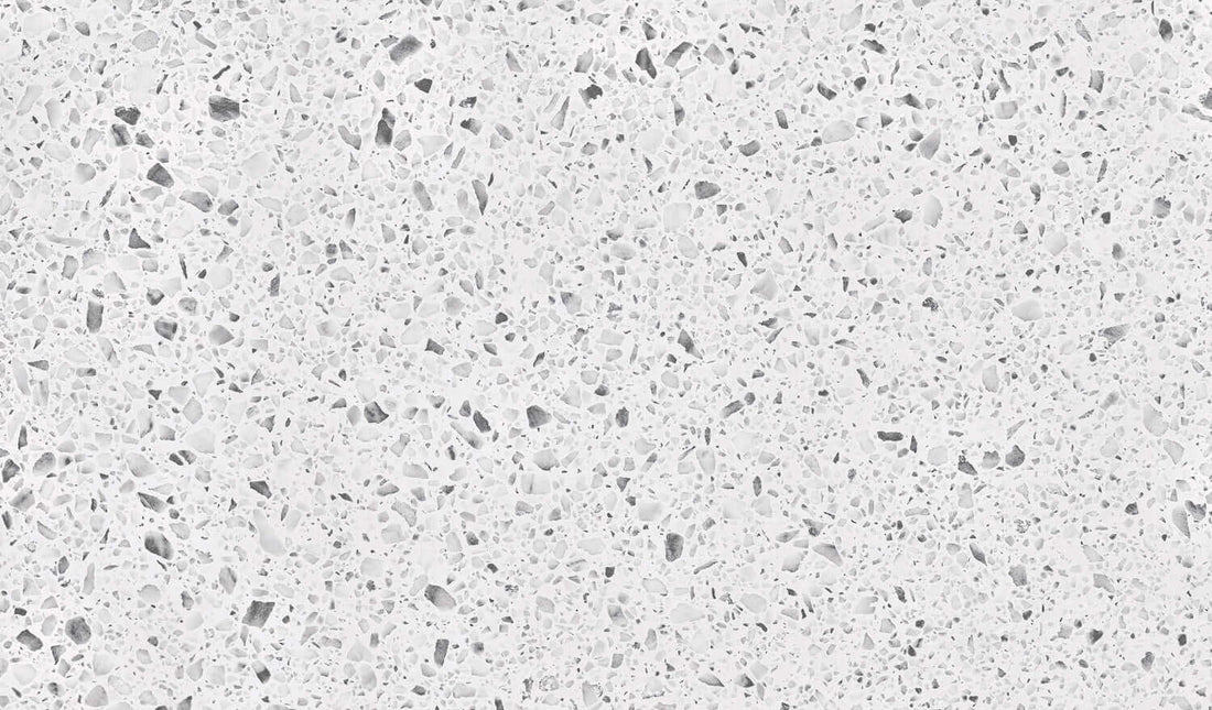 Nahaufnahme einer hellgrauen und weiß gesprenkelten Oberfläche, die an Granit erinnert, ideal für Küchenarbeitsplatten.