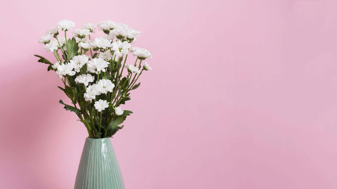 Blush Bloom - Induction Guardian Design mit rosa Hintergrund und schönen Blumen in einer Vase im Vordergrund auf der linken Seite