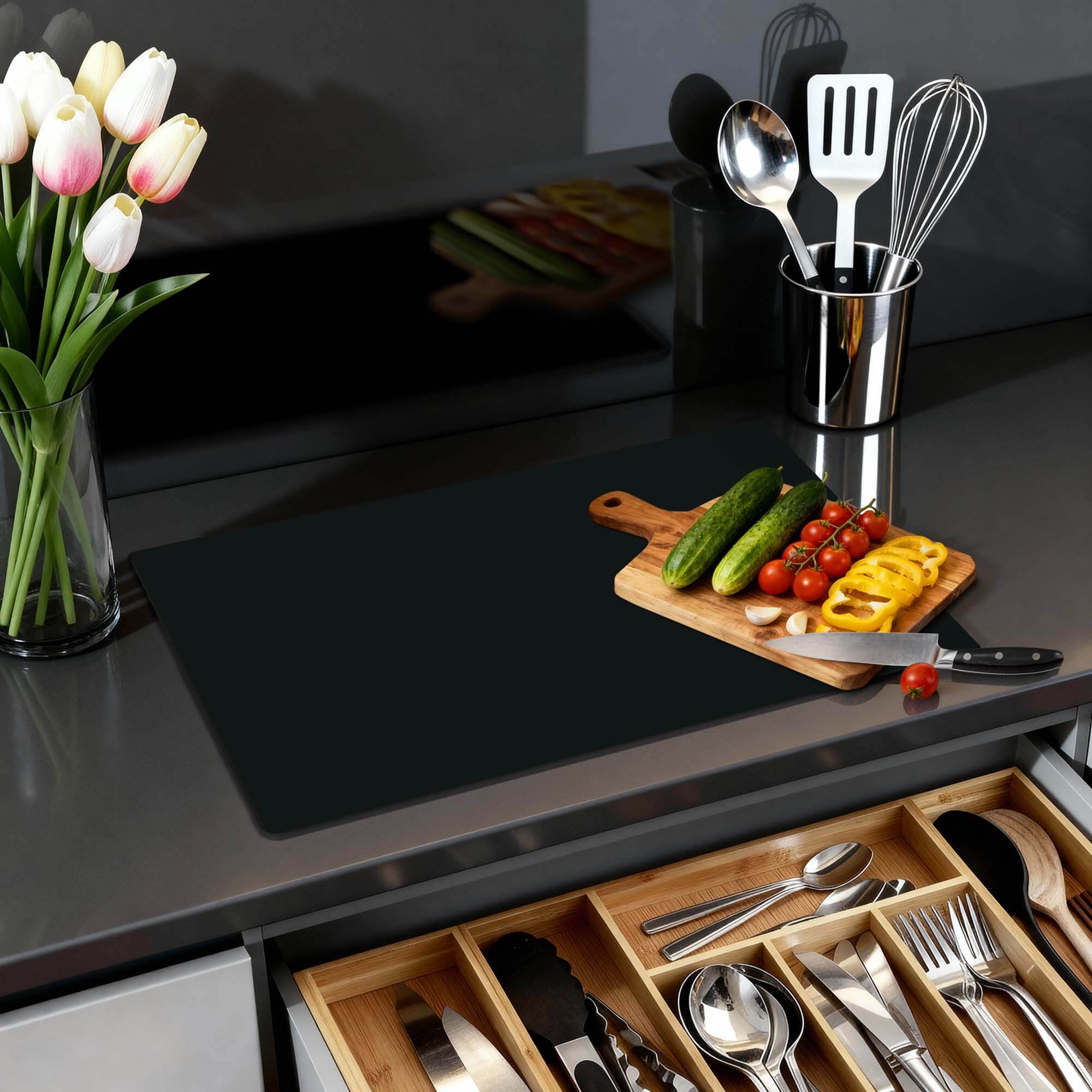 Pure Black - Herdabdeckplatte auf einer modernen Küchenarbeitsplatte mit frischem Gemüse und einem stilvollen Arrangement.