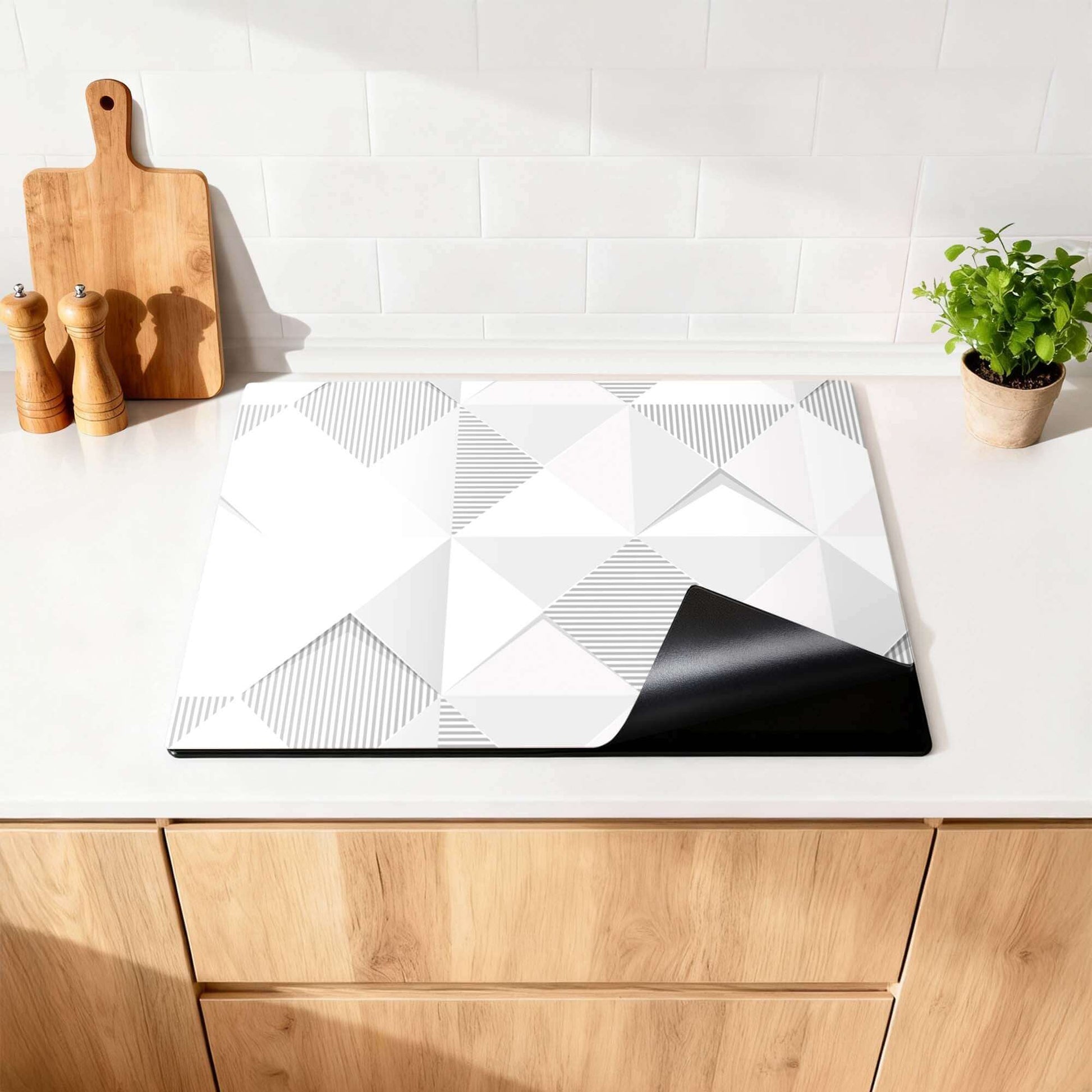 Arctic Prism - Herdabdeckplatte mit geometrischem Design in kühlen Grautönen auf einer modernen Küchenarbeitsplatte.