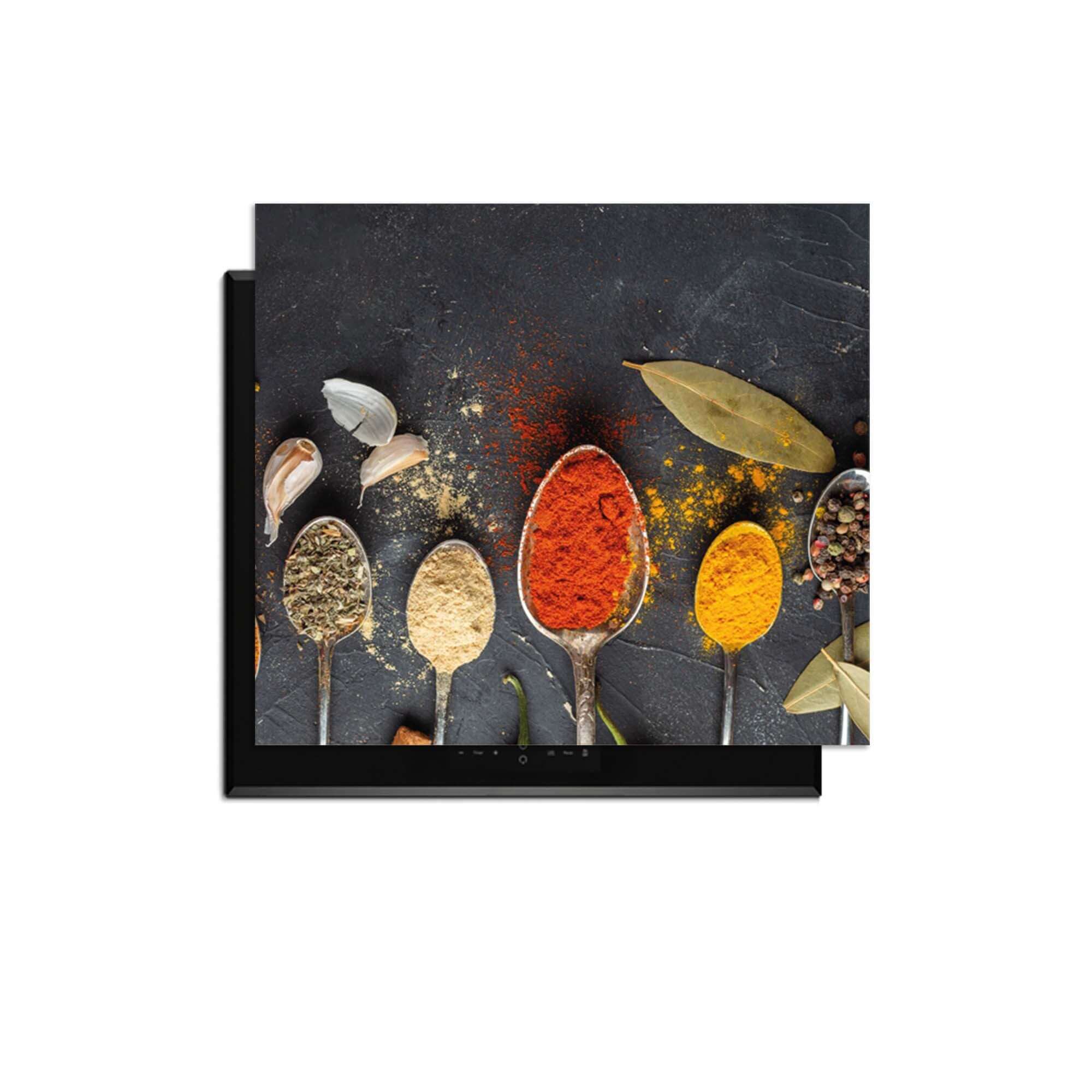 Spice Essence - Herdabdeckplatte mit eleganten Löffeln voller aromatischer Kräuter und Gewürze auf dunklem Hintergrund.