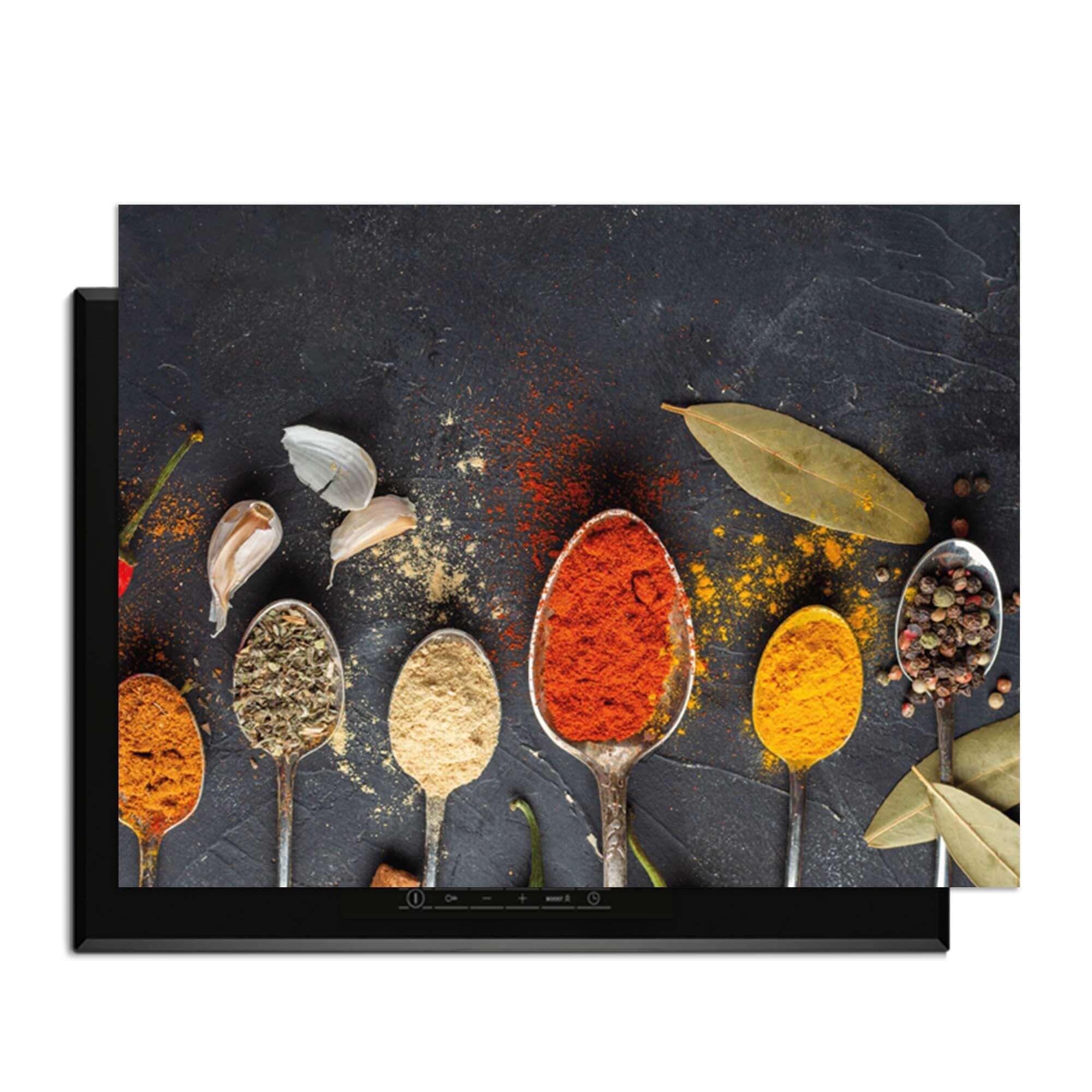 Spice Essence - Herdabdeckplatte mit Löffeln voller aromatischer Gewürze auf dunklem Hintergrund.