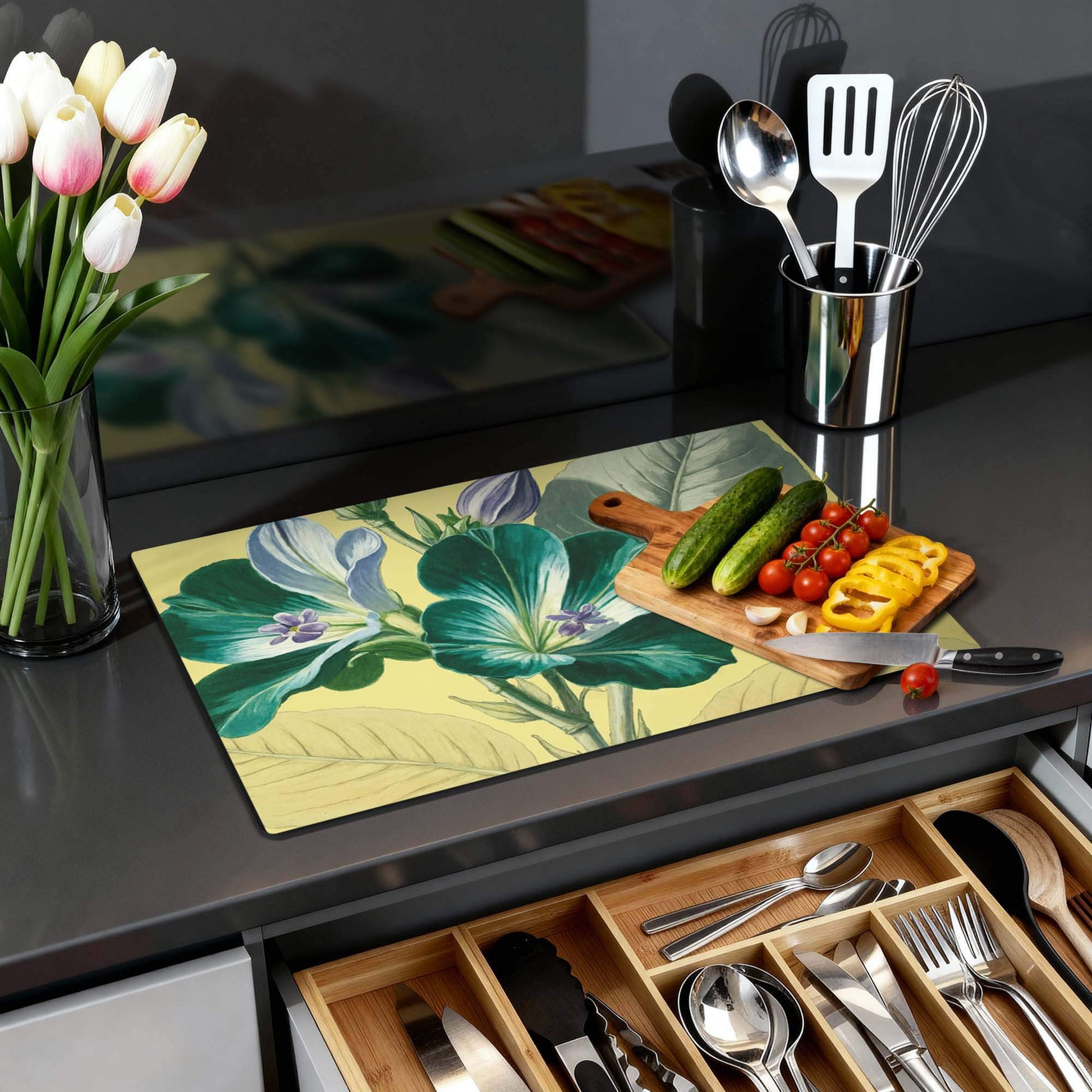 Botanical Glow - Herdabdeckplatte mit floralem Muster auf einer Küchenplatte, frischem Gemüse und Tulpen in einer Vase.