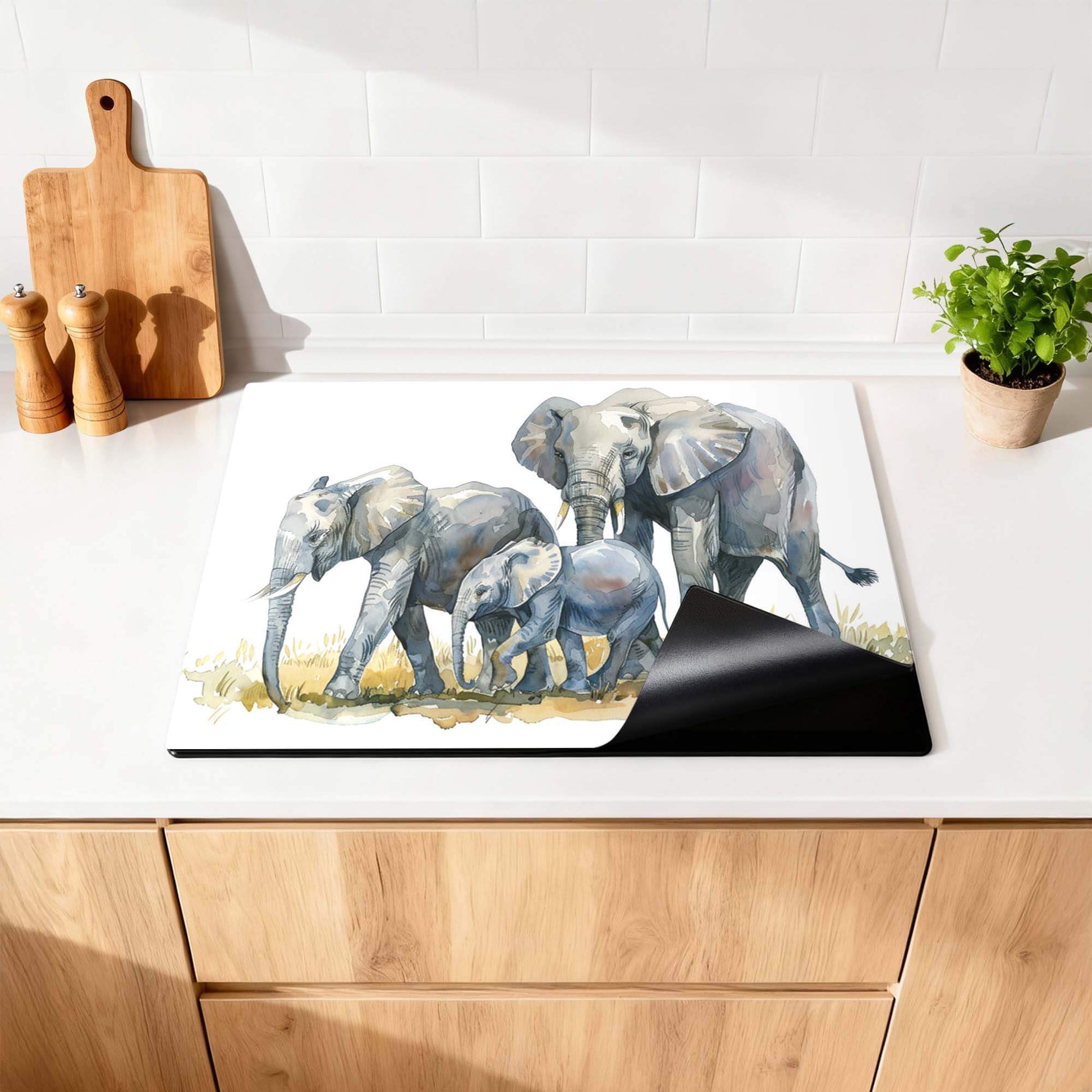 Elefantenfamilie - Herdabdeckplatte mit Aquarelldruck von Elefanten auf einer Küchenarbeitsplatte.