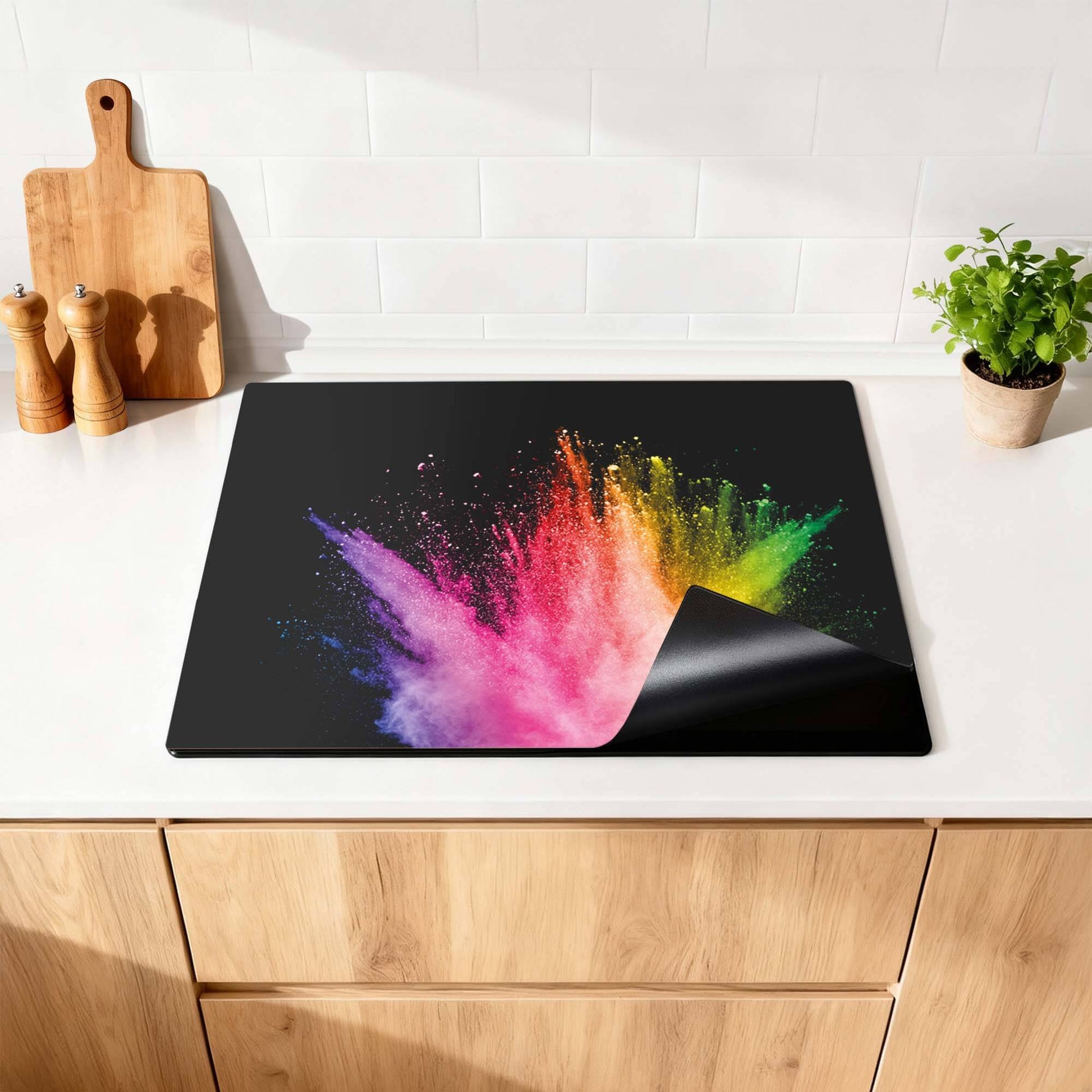 Prism Pulse - Herdabdeckplatte mit bunten Spritzern auf schwarzem Hintergrund auf einer Küchenarbeitsplatte.