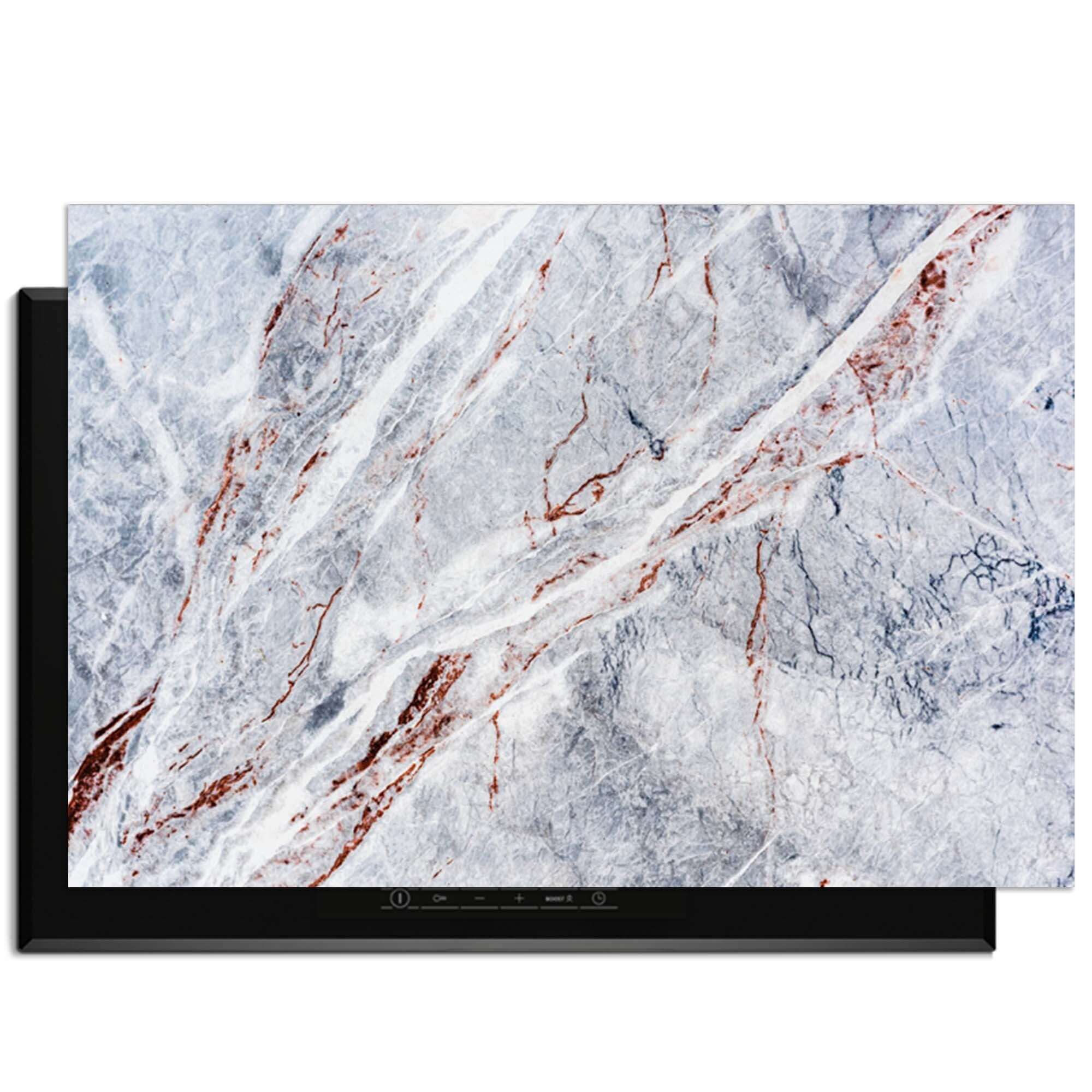 Elegantes Marmor - Herdabdeckplatte auf einem Induktionskochfeld, ideal für einen luxuriösen Look in der Küche.