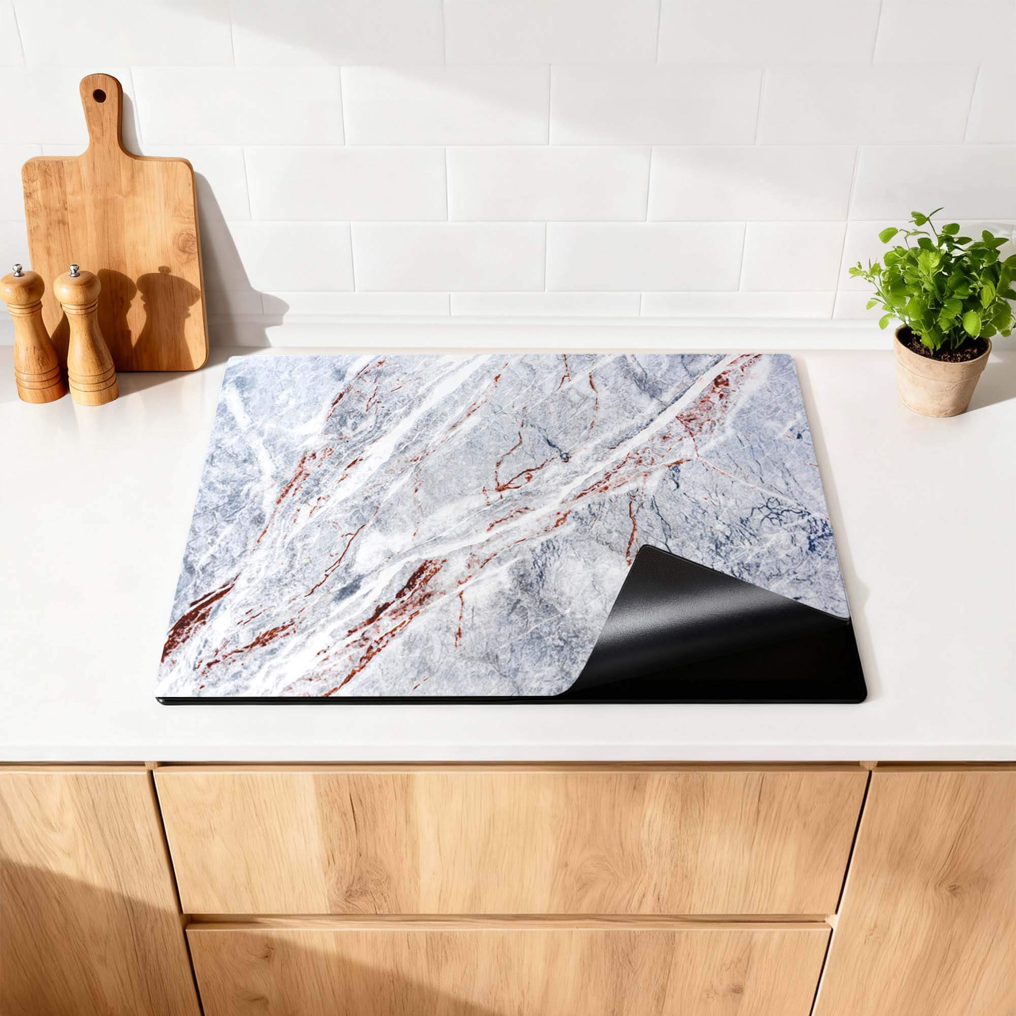 Elegantes Marmor - Herdabdeckplatte auf einer modernen Küchenarbeitsplatte, luxuriöses Aussehen und praktischer Schutz.