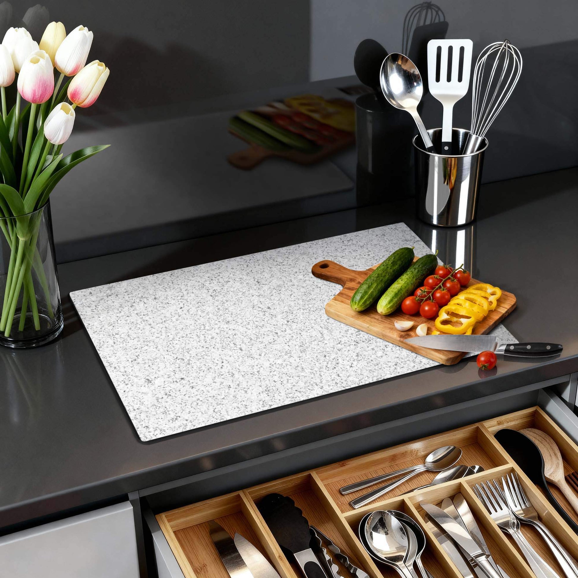 Arctic Granite - Herdabdeckplatte auf dem Kochfeld mit Gemüse und Blumen, elegantes Küchendesign.