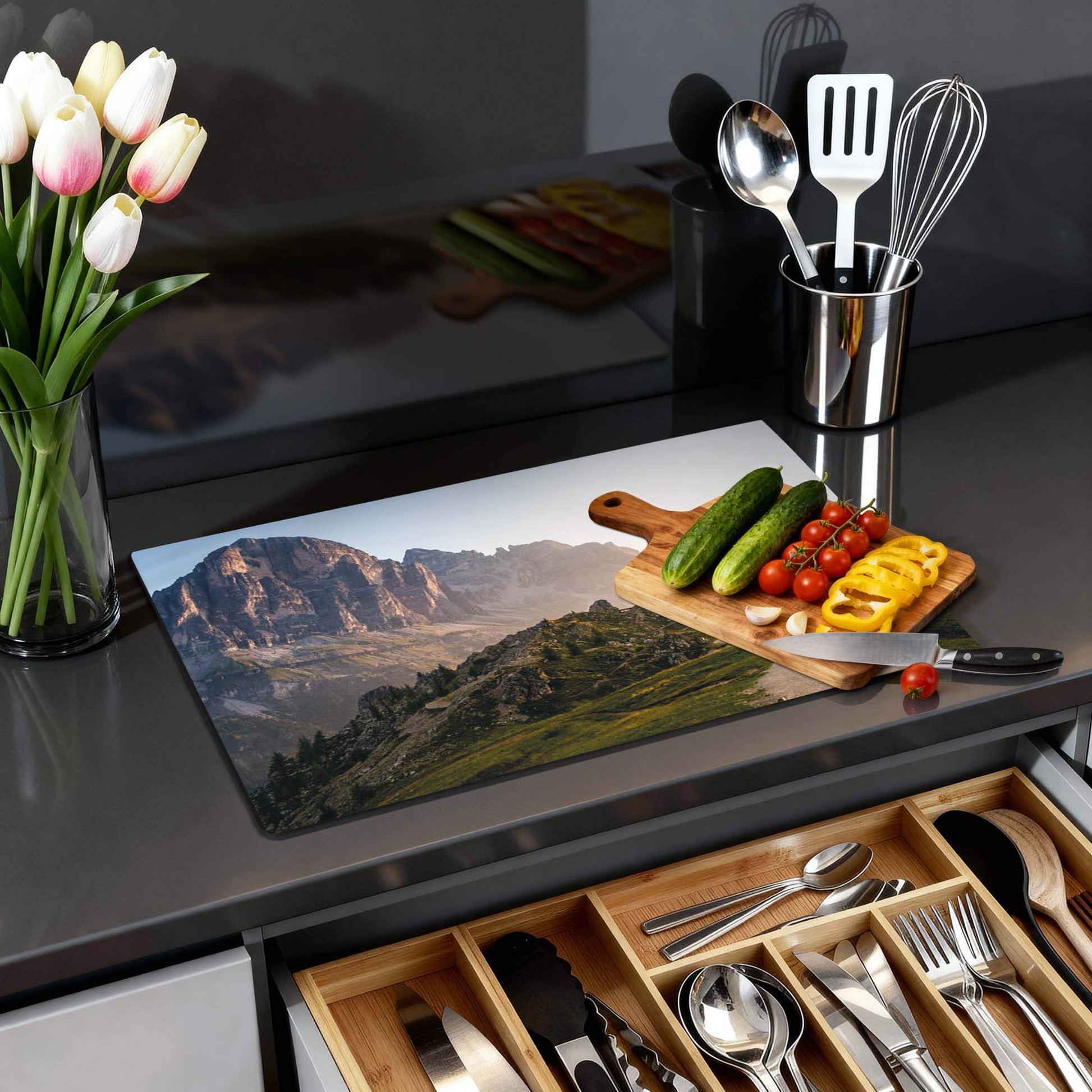 Morning Trails - Herdabdeckplatte mit einer Berglandschaft und frischem Gemüse auf einer Arbeitsplatte.