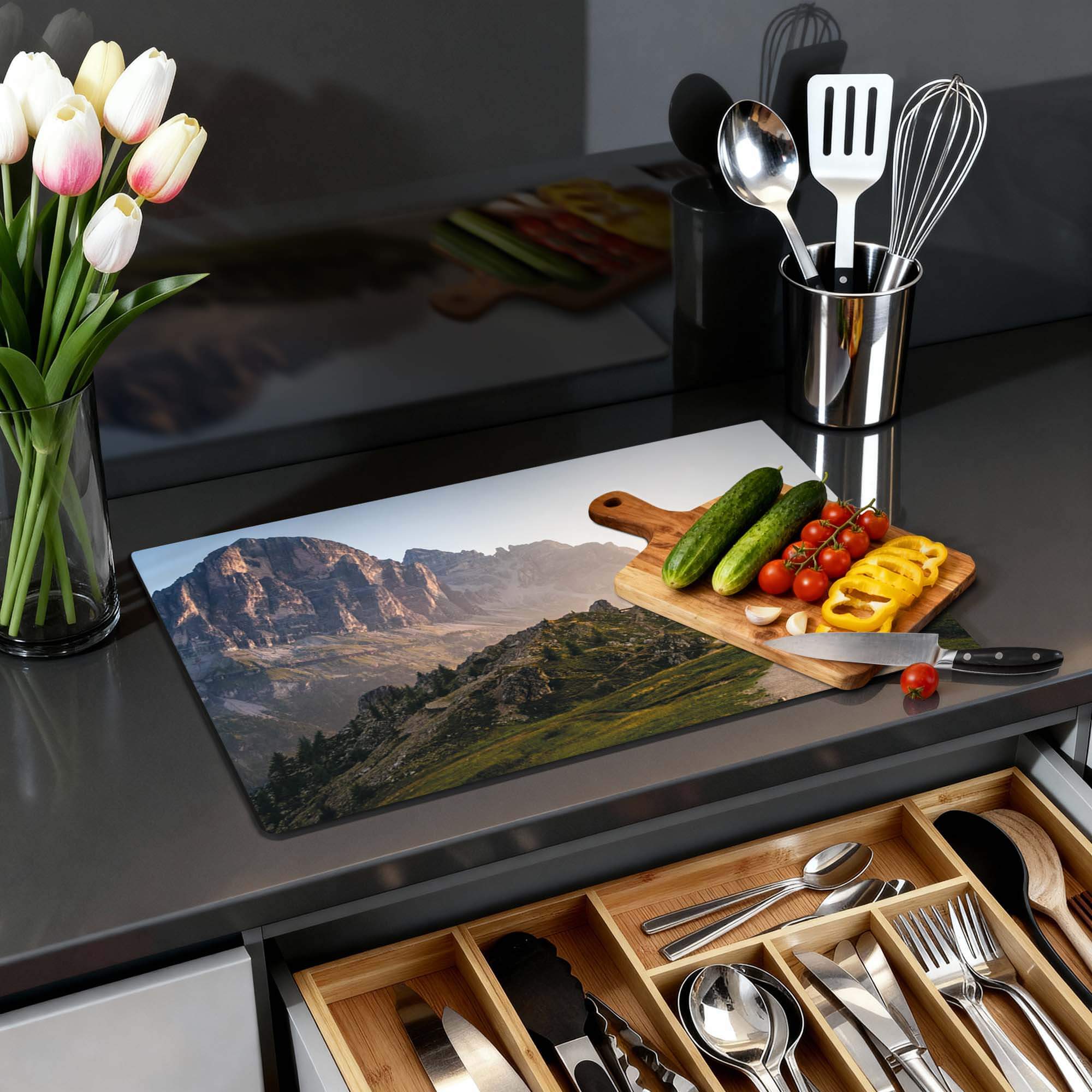 Morning Trails - Herdabdeckplatte mit einer Berglandschaft und frischem Gemüse auf einer Arbeitsplatte.