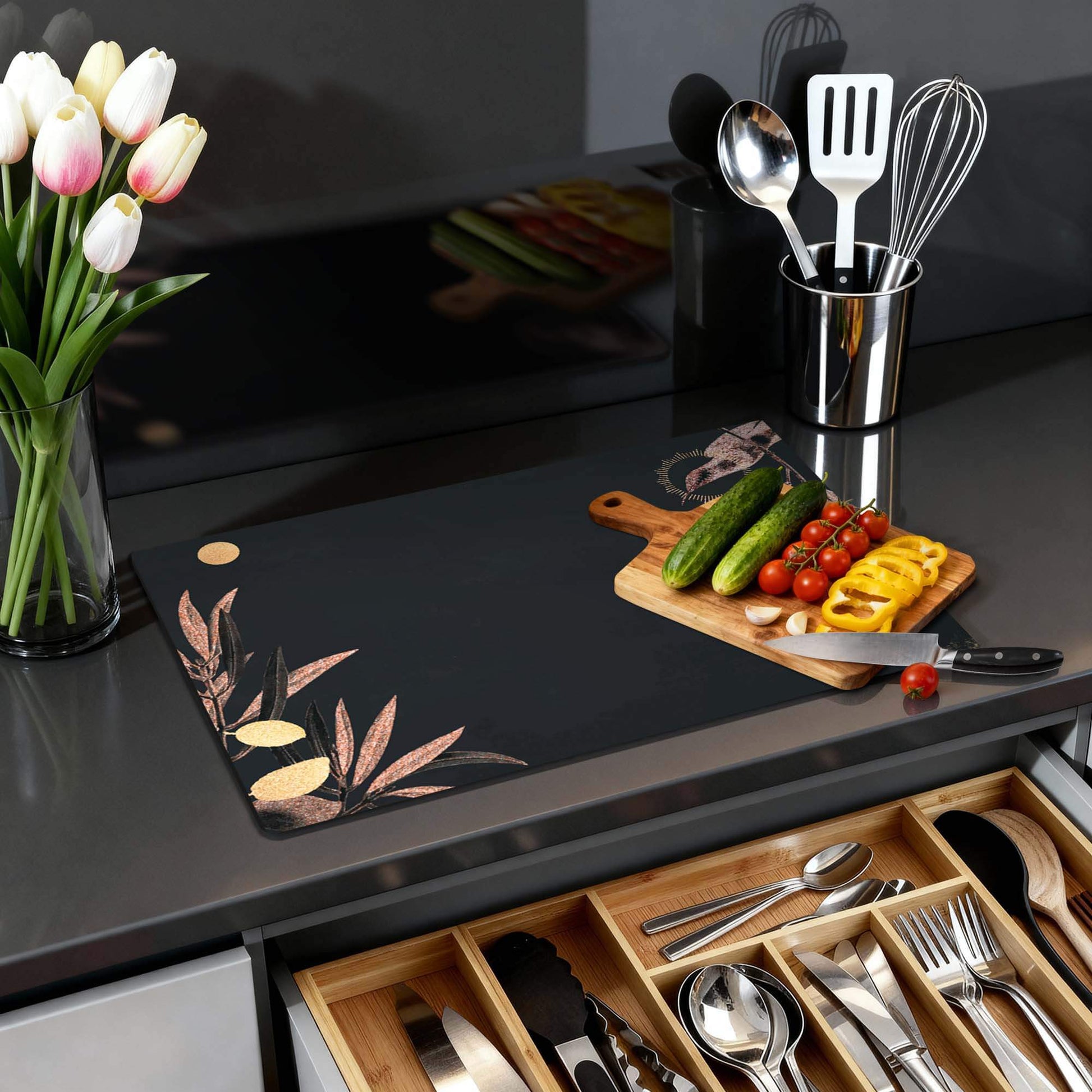 Golden Olive - Herdabdeckplatte auf einer modernen Küchenarbeitsplatte mit Gemüse und Blumen.