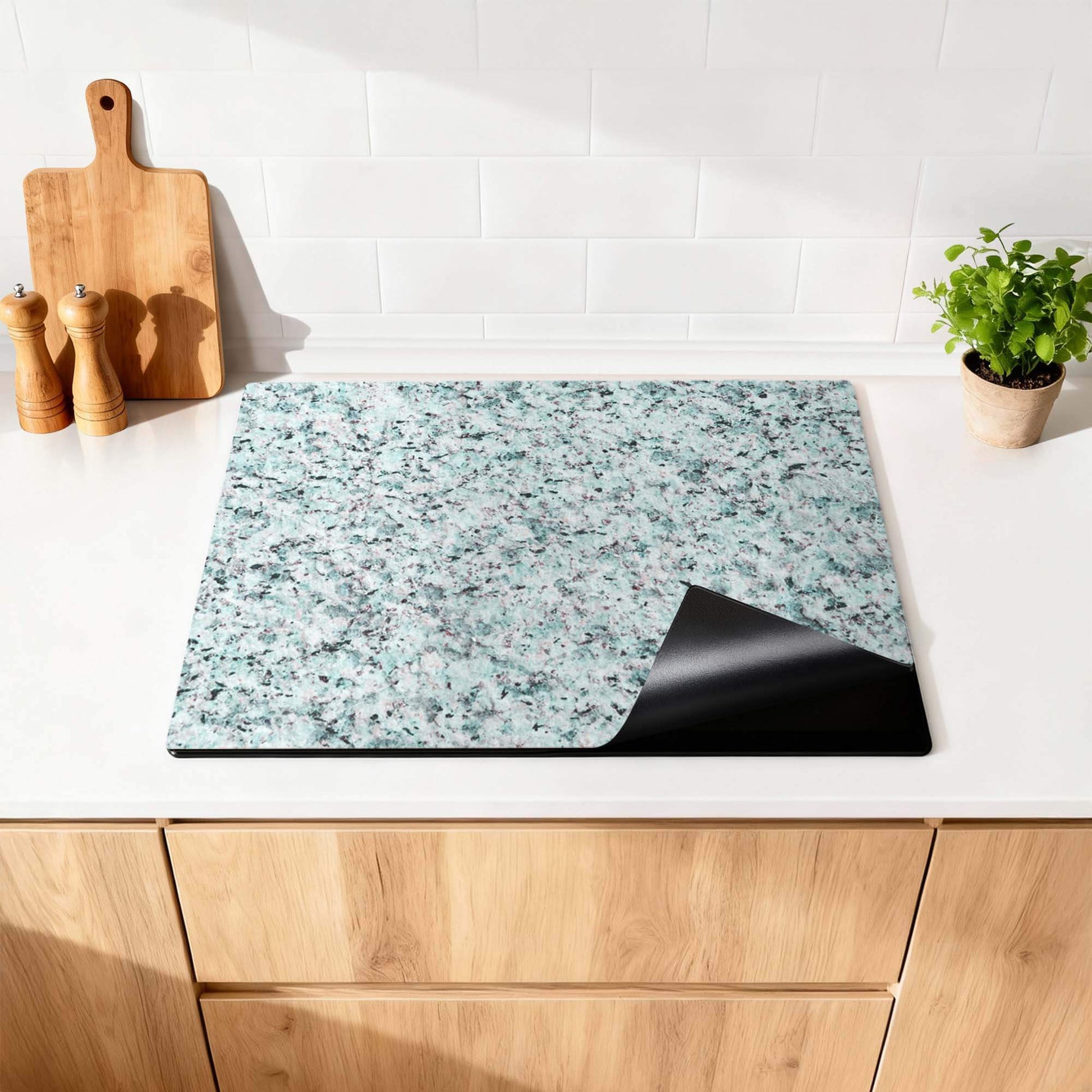 Baltic Mist - Herdabdeckplatte mit modernem blau-grauem Granitdesign auf der Küchenarbeitsplatte.