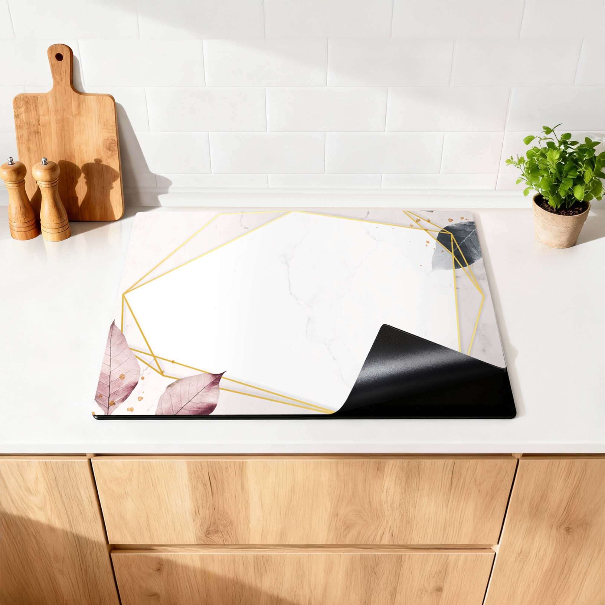 Geometrische Eleganz - Herdabdeckplatte mit weißem Marmormuster und goldenen Linien auf einer modernen Küchenoberfläche.