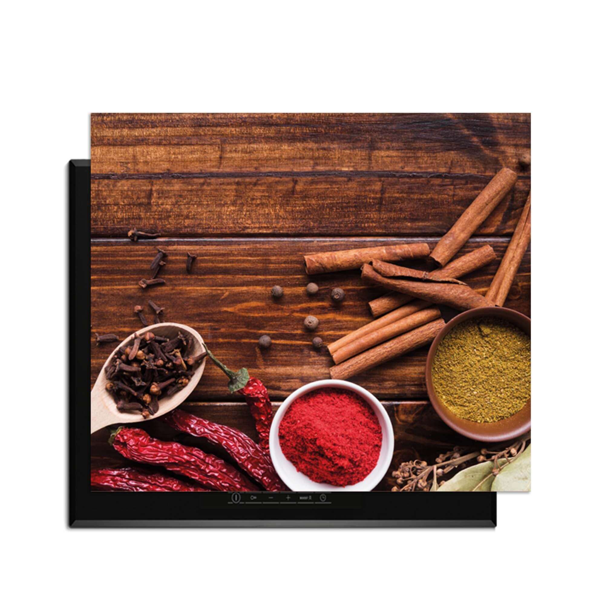 Warm Spice Harmony - Herdabdeckplatte mit bunten Gewürzen auf einem Holztisch.