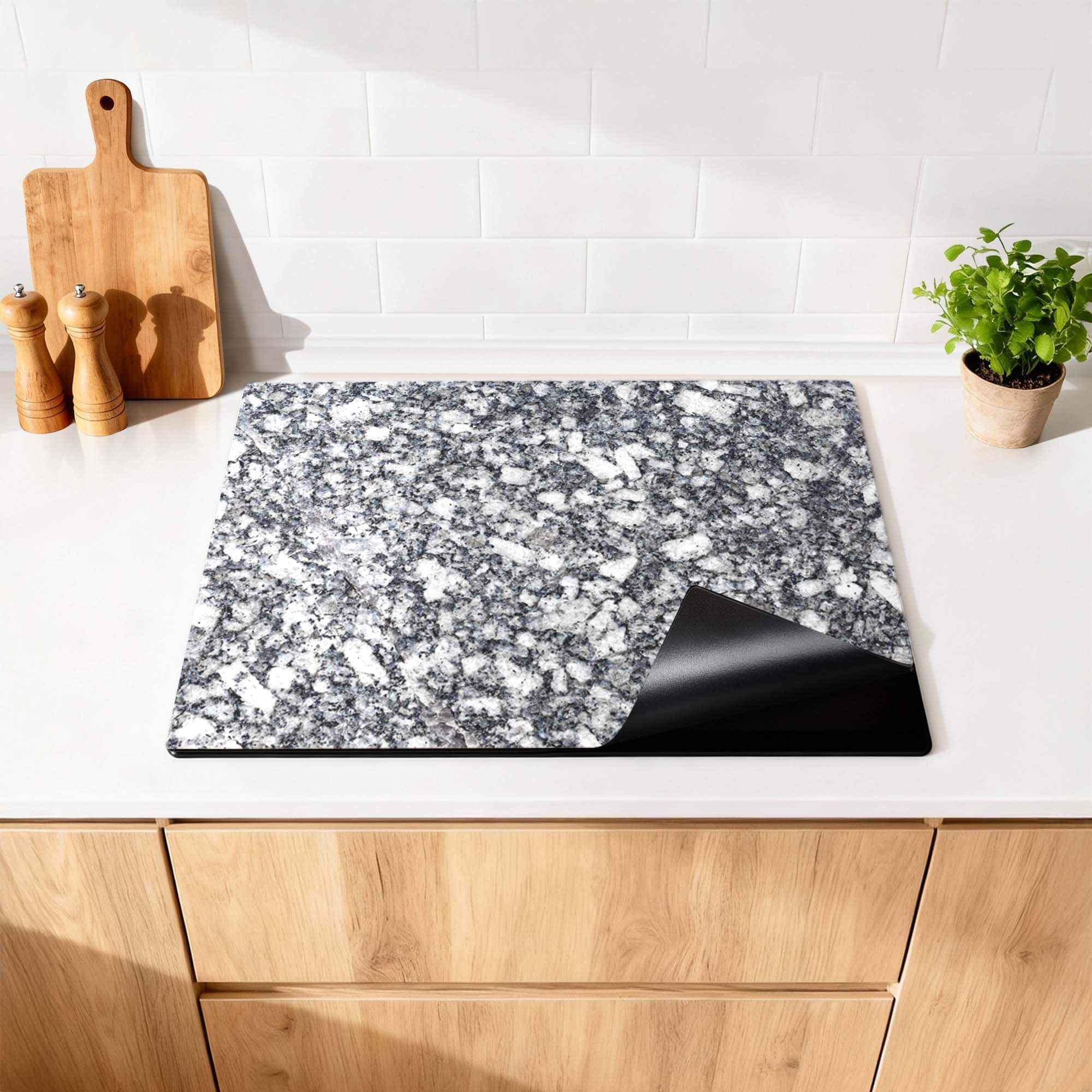 Midnight Granite - Herdabdeckplatte auf einer modernen Küchenarbeitsplatte, bietet Luxus und Schutz für Ihr Kochfeld.