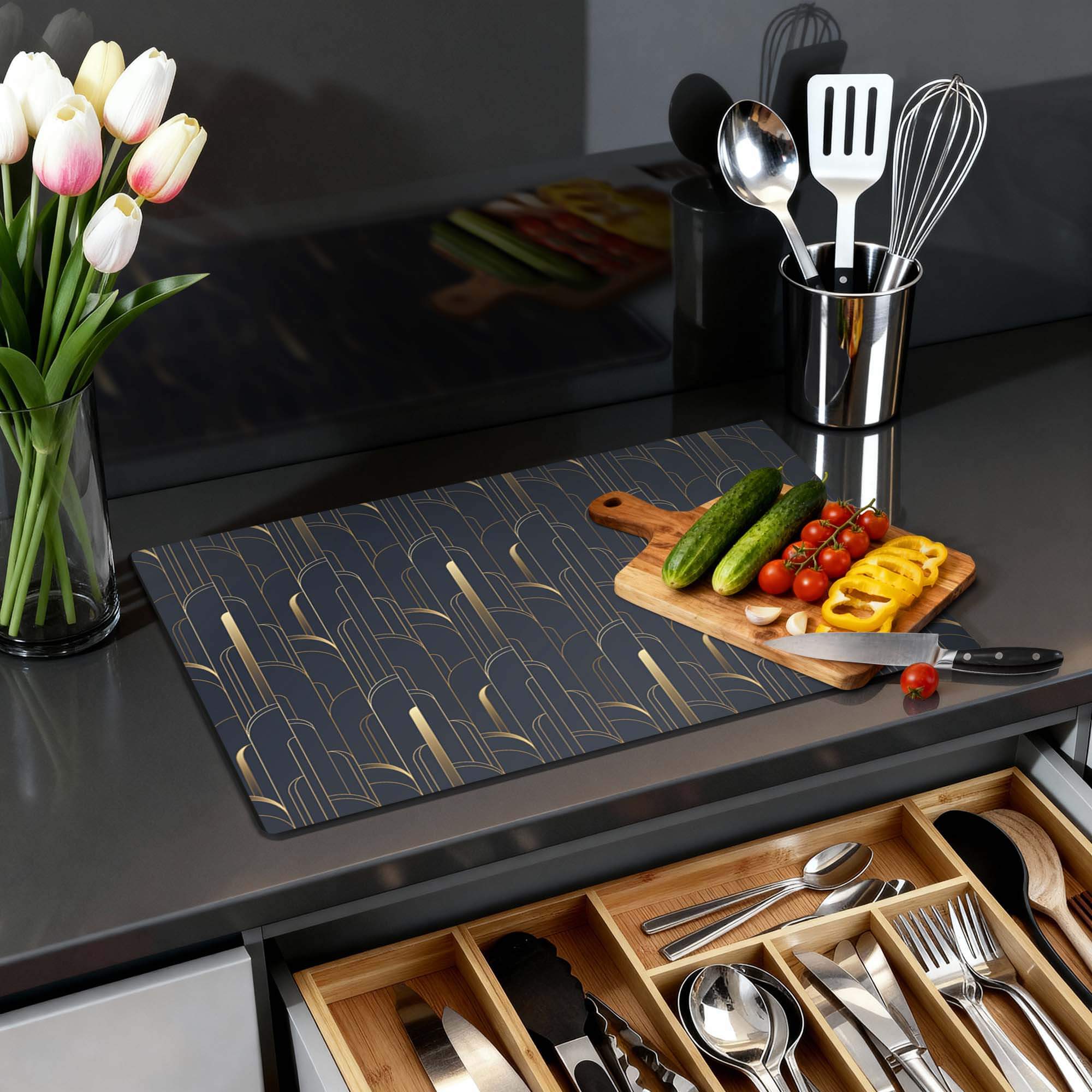 Art Deco Lines - Herdabdeckplatte auf einer eleganten Küchenarbeitsplatte mit Gemüse und Utensilien.