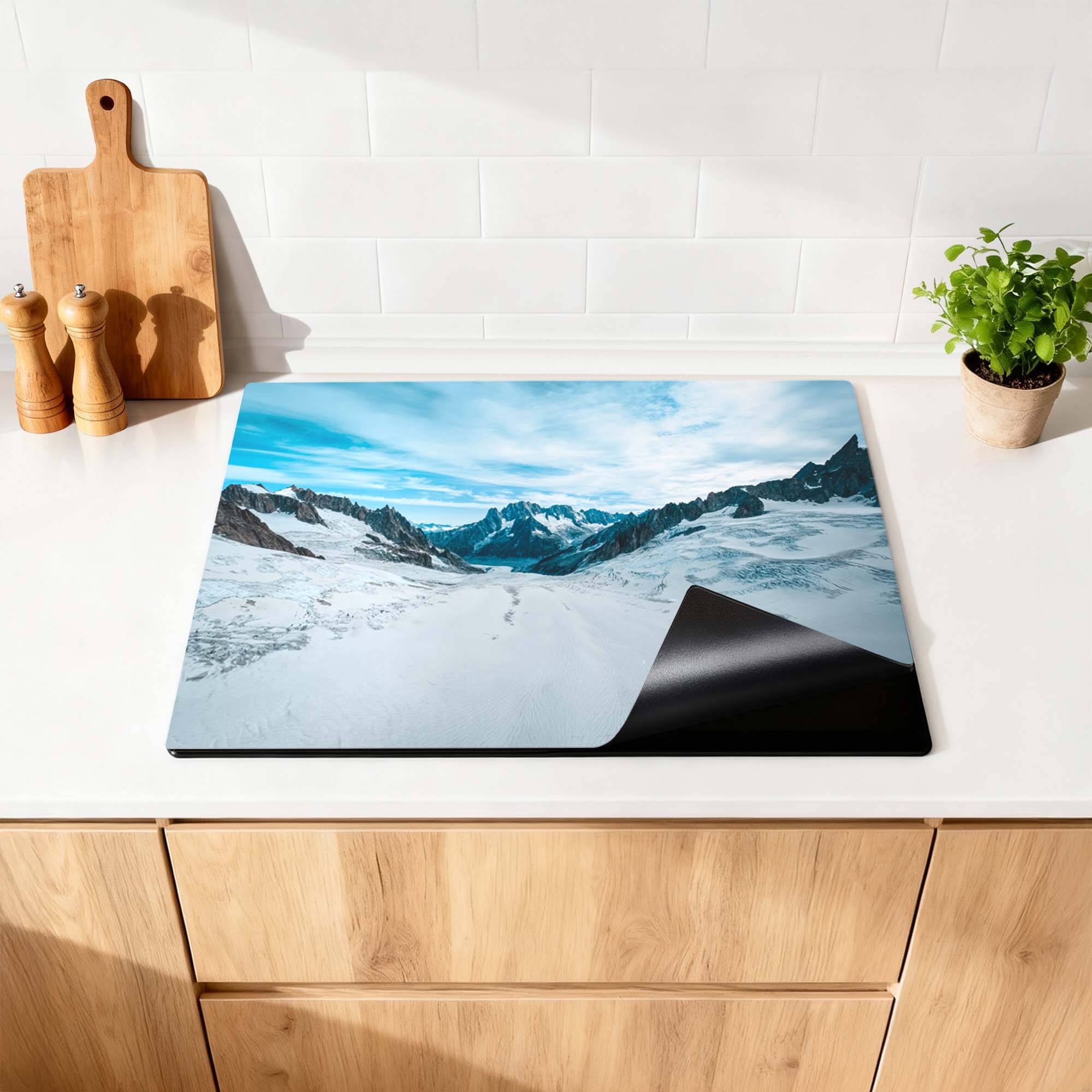 Frozen Peaks - Herdabdeckplatte auf einer Küchenplatte mit verschneiten Bergen.