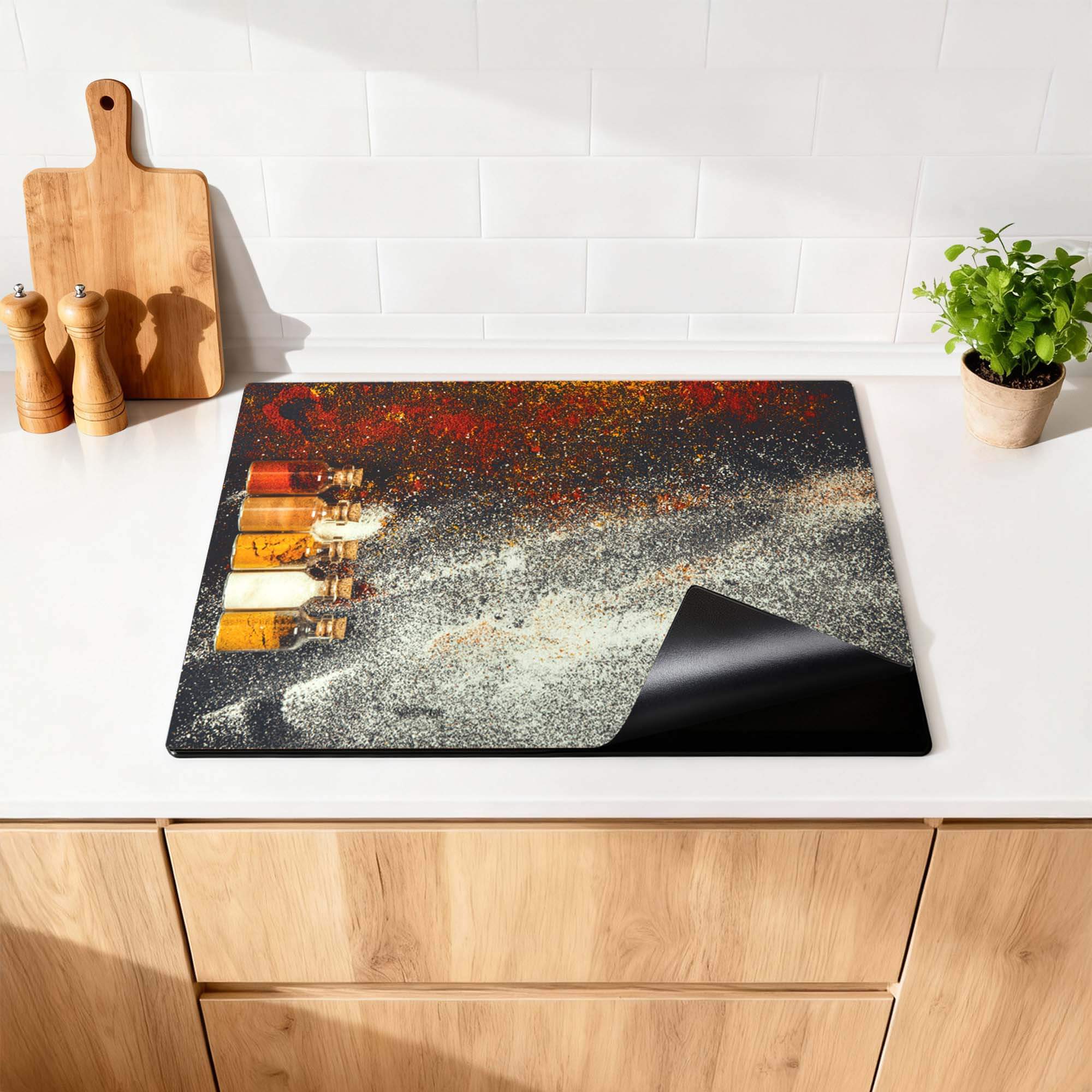 Gewürzflaschen - Herdabdeckplatte auf einer Küchenarbeitsplatte mit Gewürzflaschen und einem bunten Design.