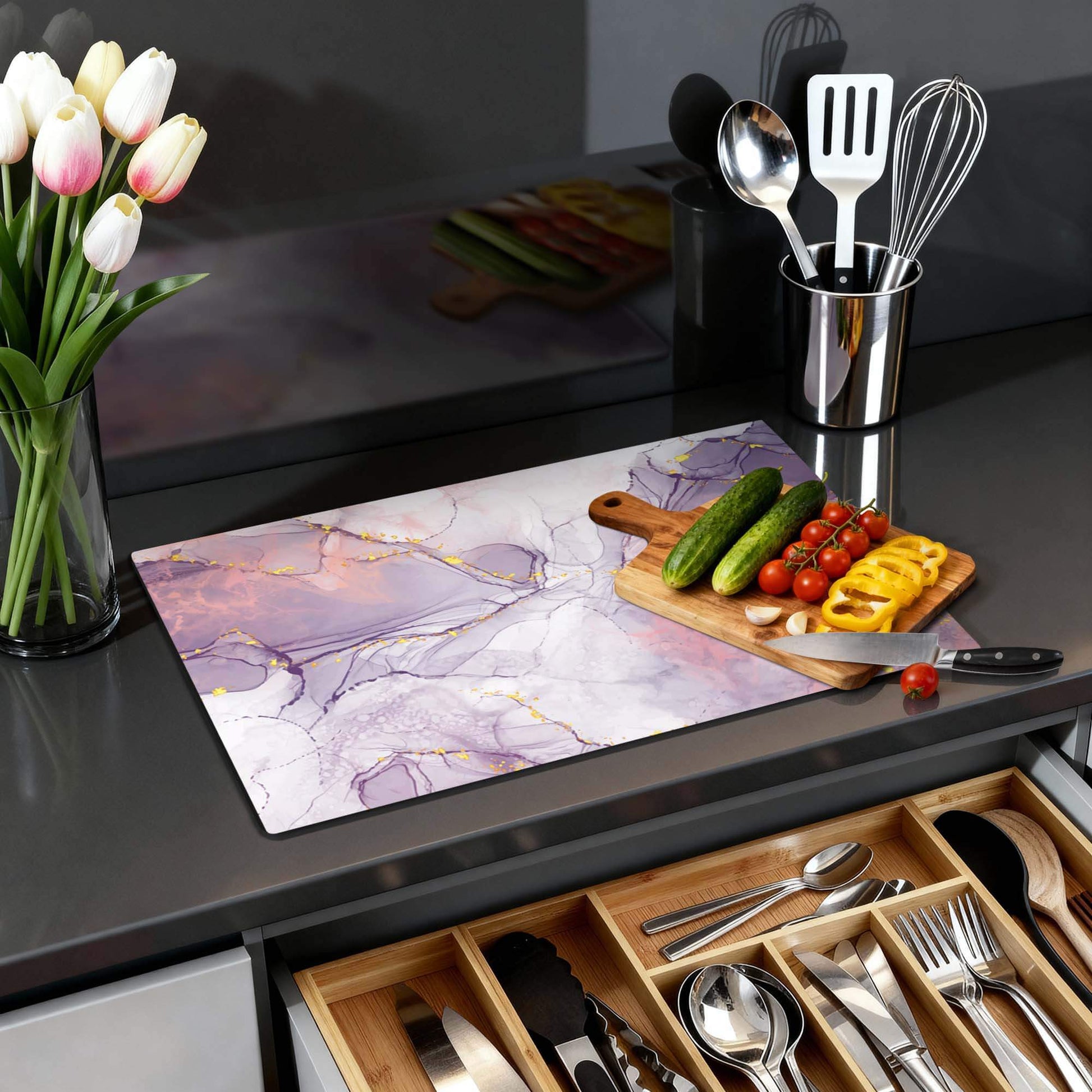 Lavendelmarmor - Herdabdeckplatte auf einer Küchenplatte mit Gemüse und Blumen.