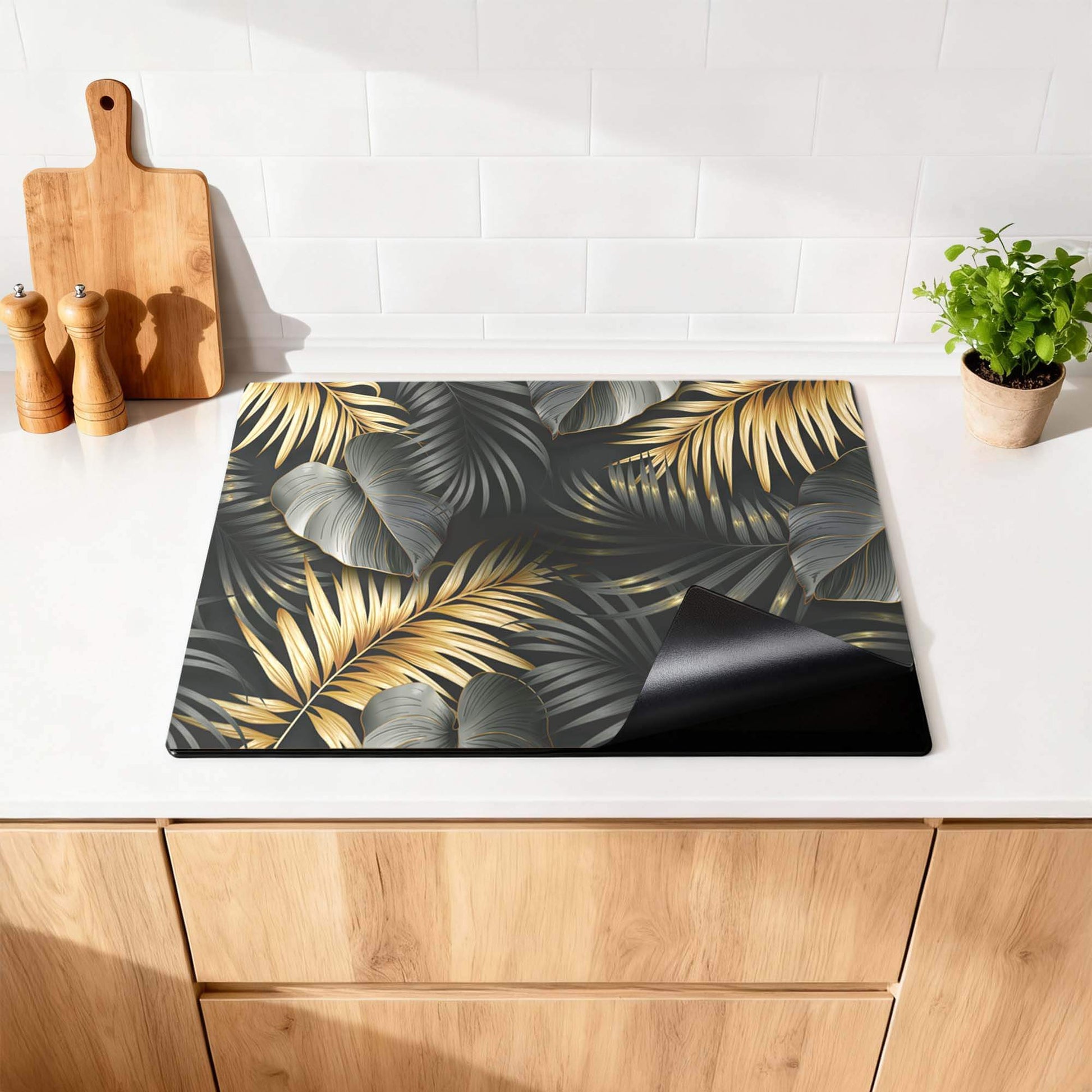 Goldene Palmen - Herdabdeckplatte mit gold- und silbergrauen Palmenblättern in der Luxusküche.