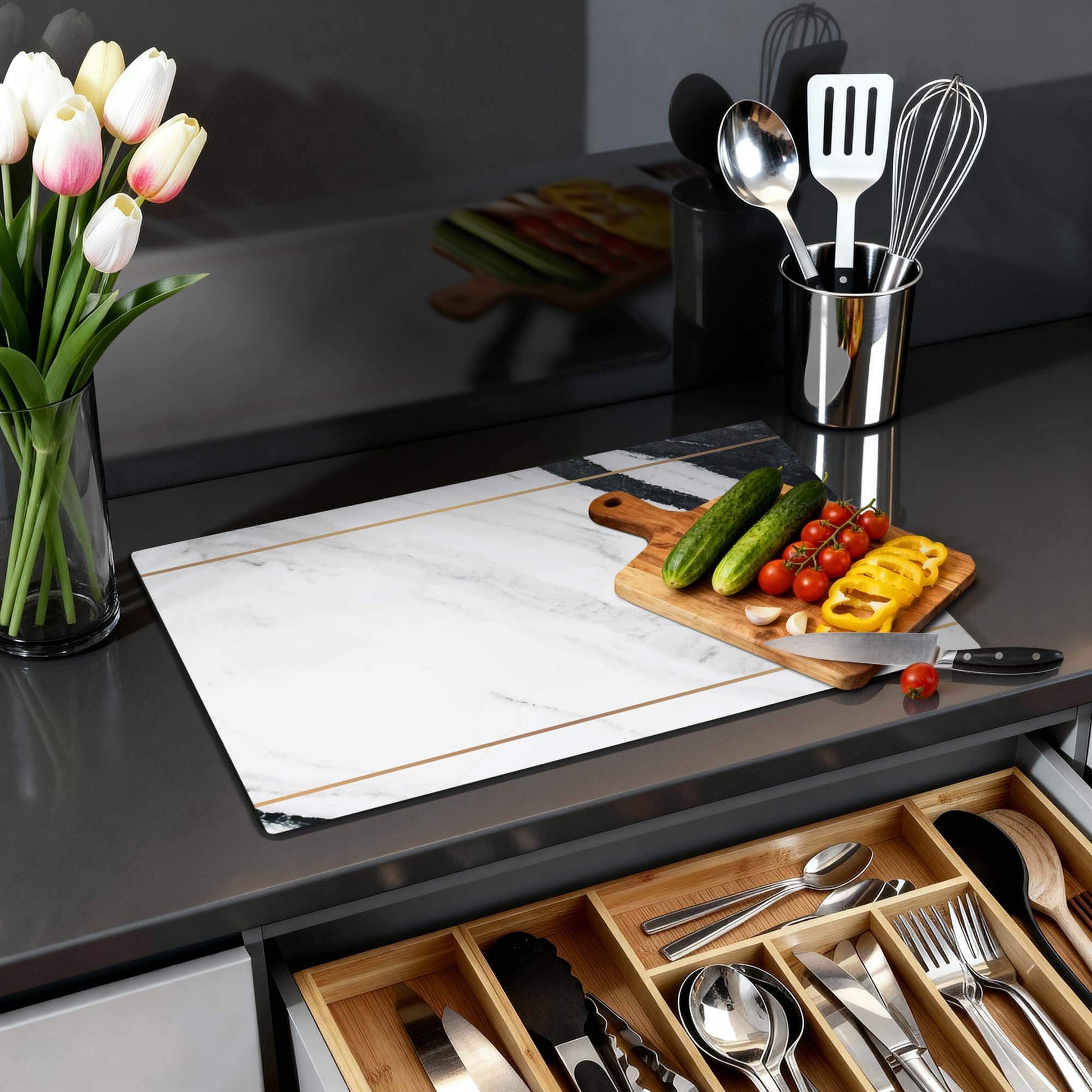 Marble Modern - Herdabdeckplatte auf einer modernen Küchenarbeitsplatte mit Gemüse und Blumen.