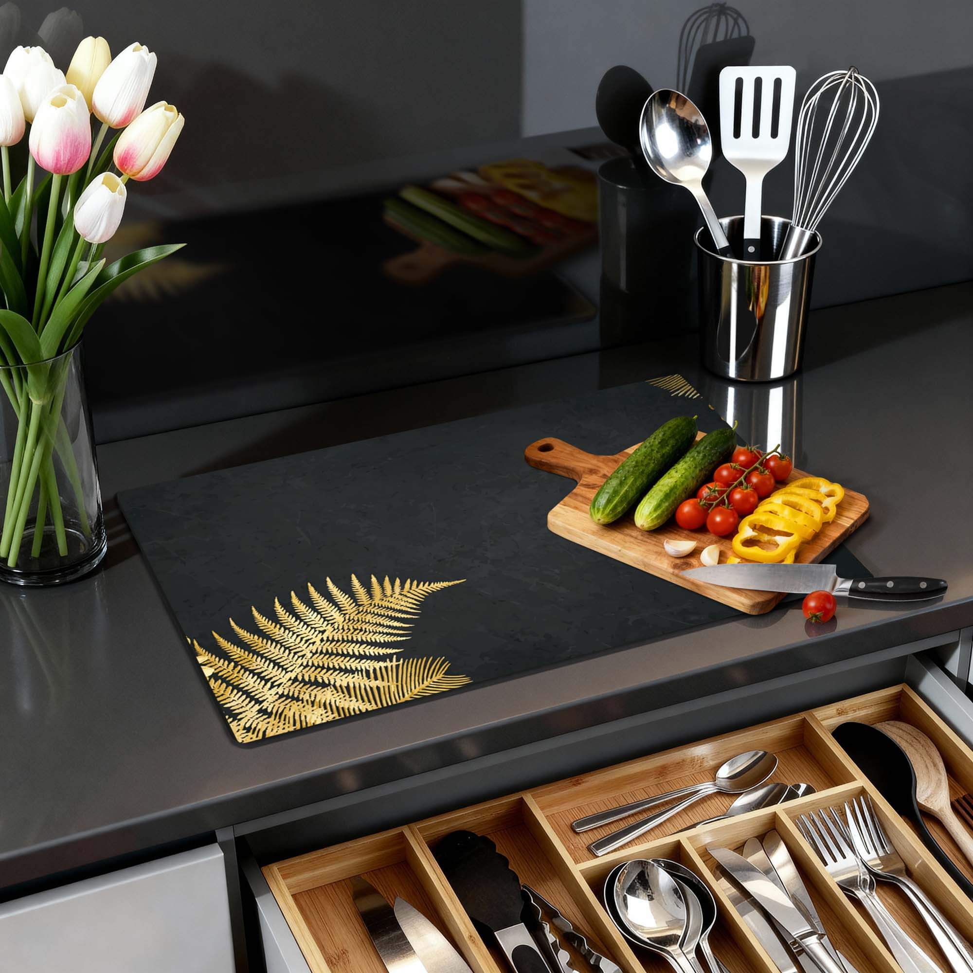 Golden Fern Touch - Herdabdeckplatte auf einer Küchenplatte mit Gemüse und Blumen.