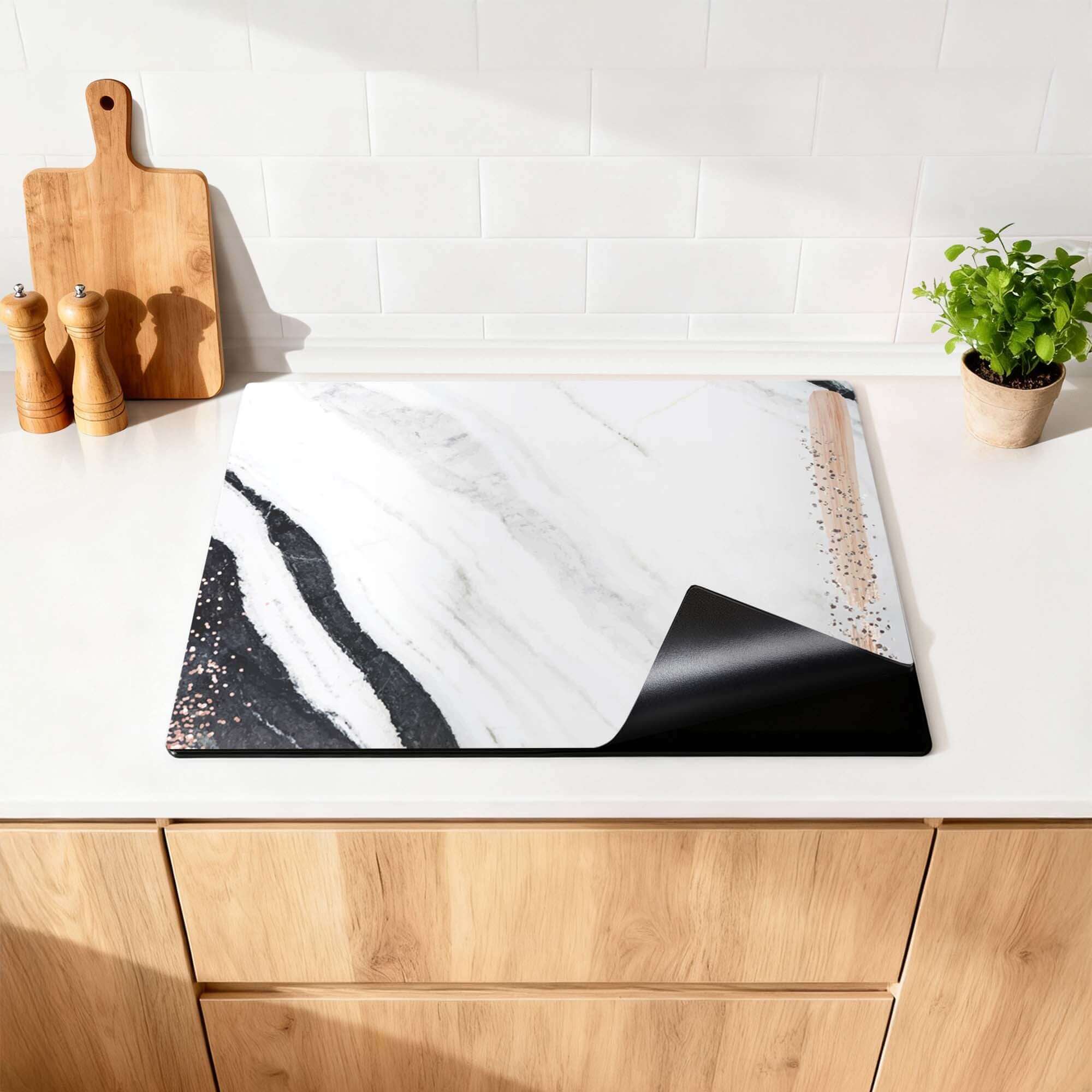 Marble Blush - Herdabdeckplatte mit luxuriöser Marmoroptik und Details in Blush und Bronze auf einer Küchenarbeitsplatte.