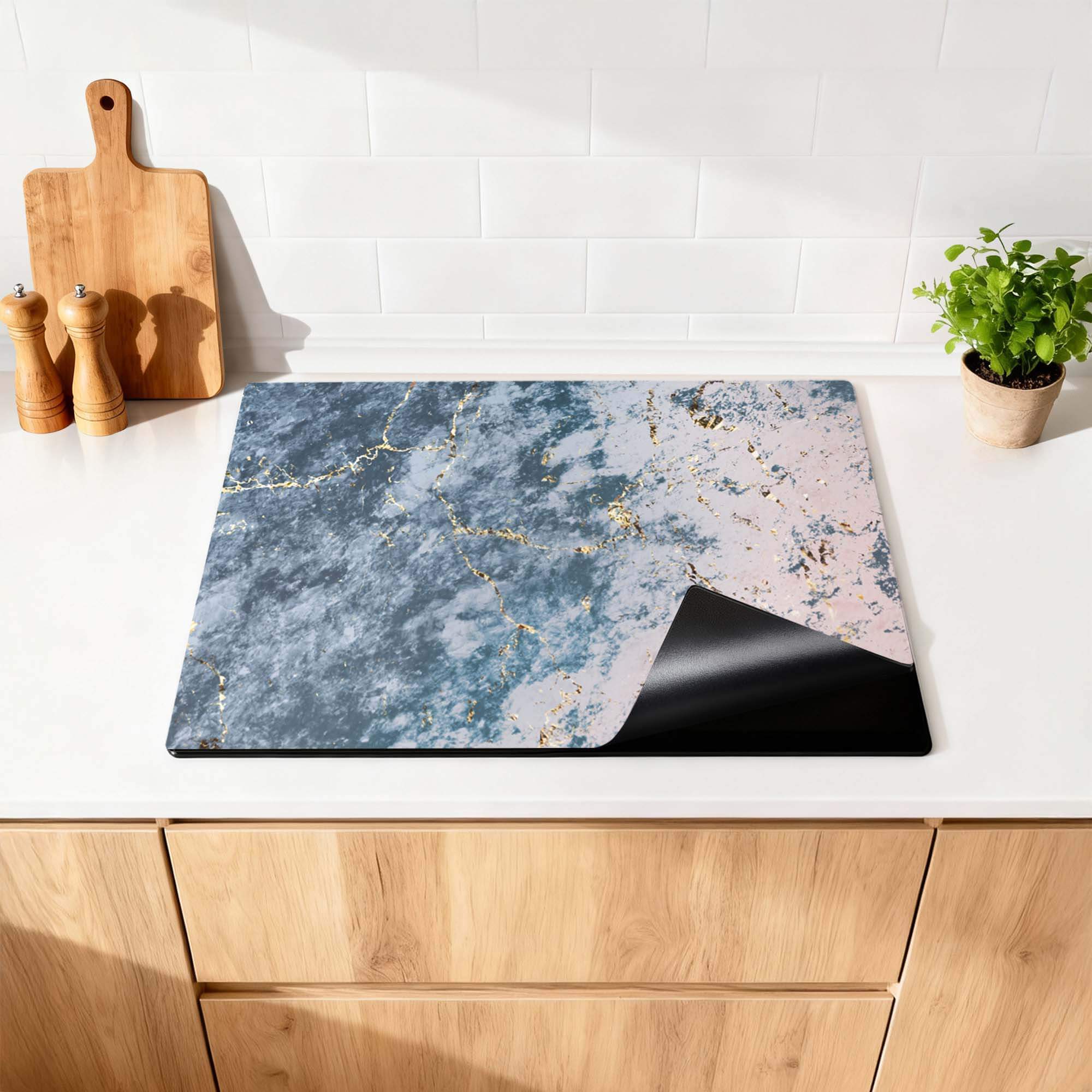 Elegantes Ocean Marble - Herdabdeckplatte auf einer Küchenarbeitsplatte mit einem luxuriösen Marmormuster in Blau- und Rosatönen.
