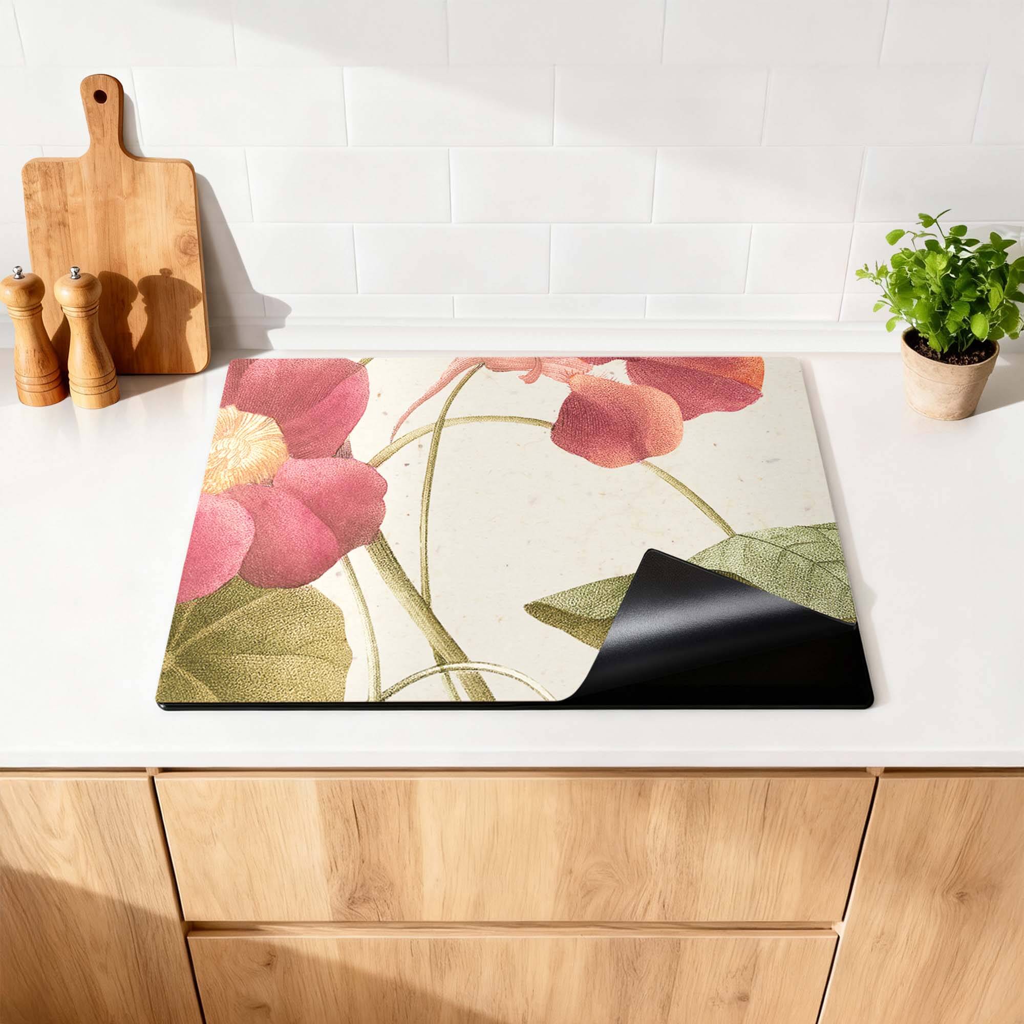 Petal Whisper - Herdabdeckplatte auf einer Küchenplatte mit Blumendruck und schwarzer Unterlage.