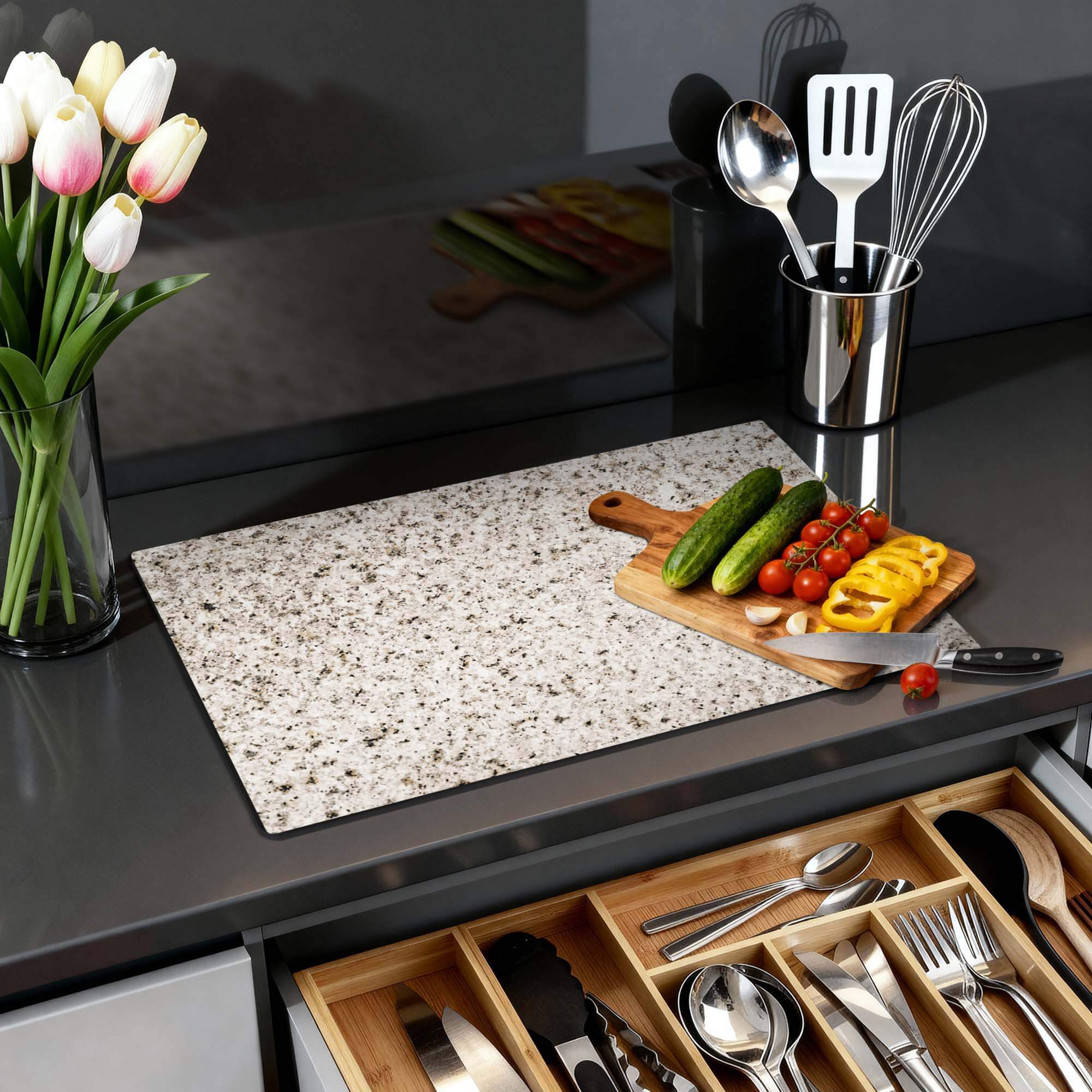 Almond Granite - Herdabdeckplatte auf der Küchenarbeitsplatte mit Gemüse und Blumen.