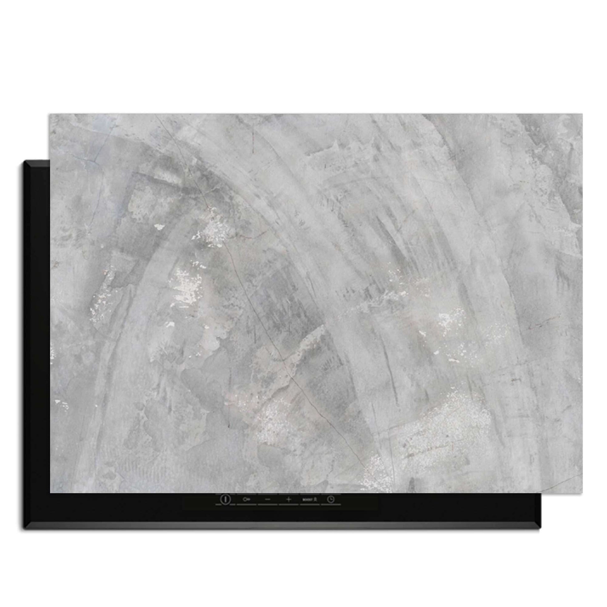 Concrete Flow - Herdabdeckplatte auf einem Induktionskochfeld mit einem eleganten grauen Design.
