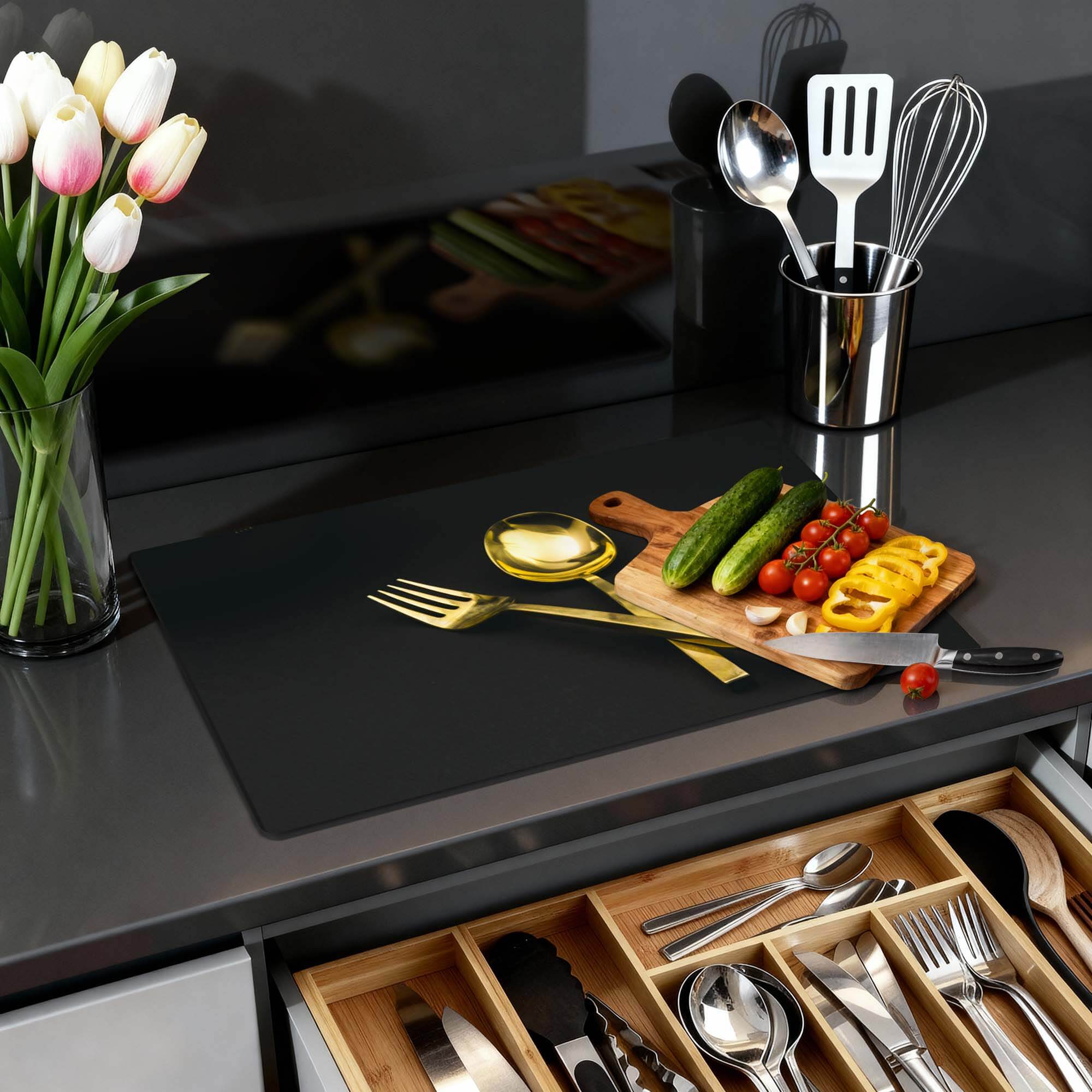 Dining Deluxe - Herdabdeckplatte auf einer modernen Küchenplatte mit Gemüse und Blumen.