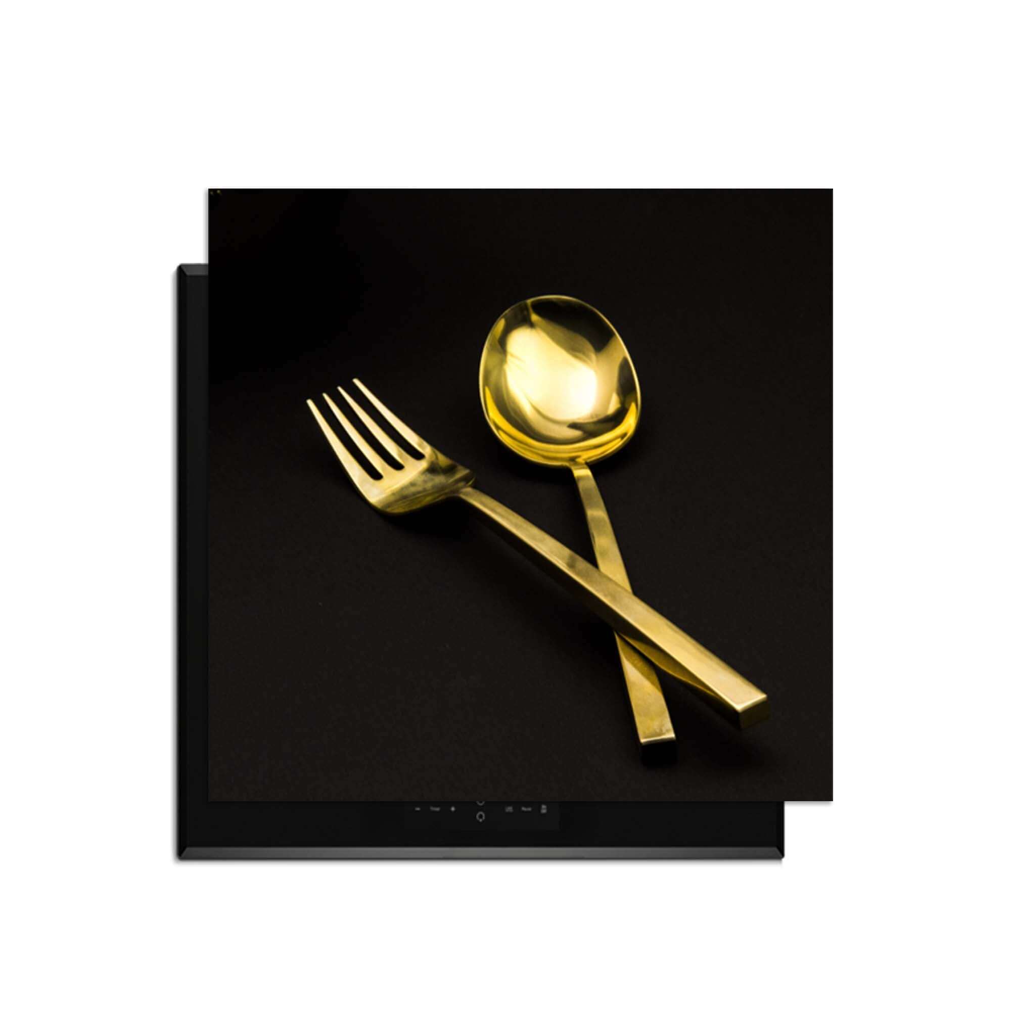 Dining Deluxe - Herdabdeckplatte mit luxuriösem Goldbesteck auf schwarzem Hintergrund.