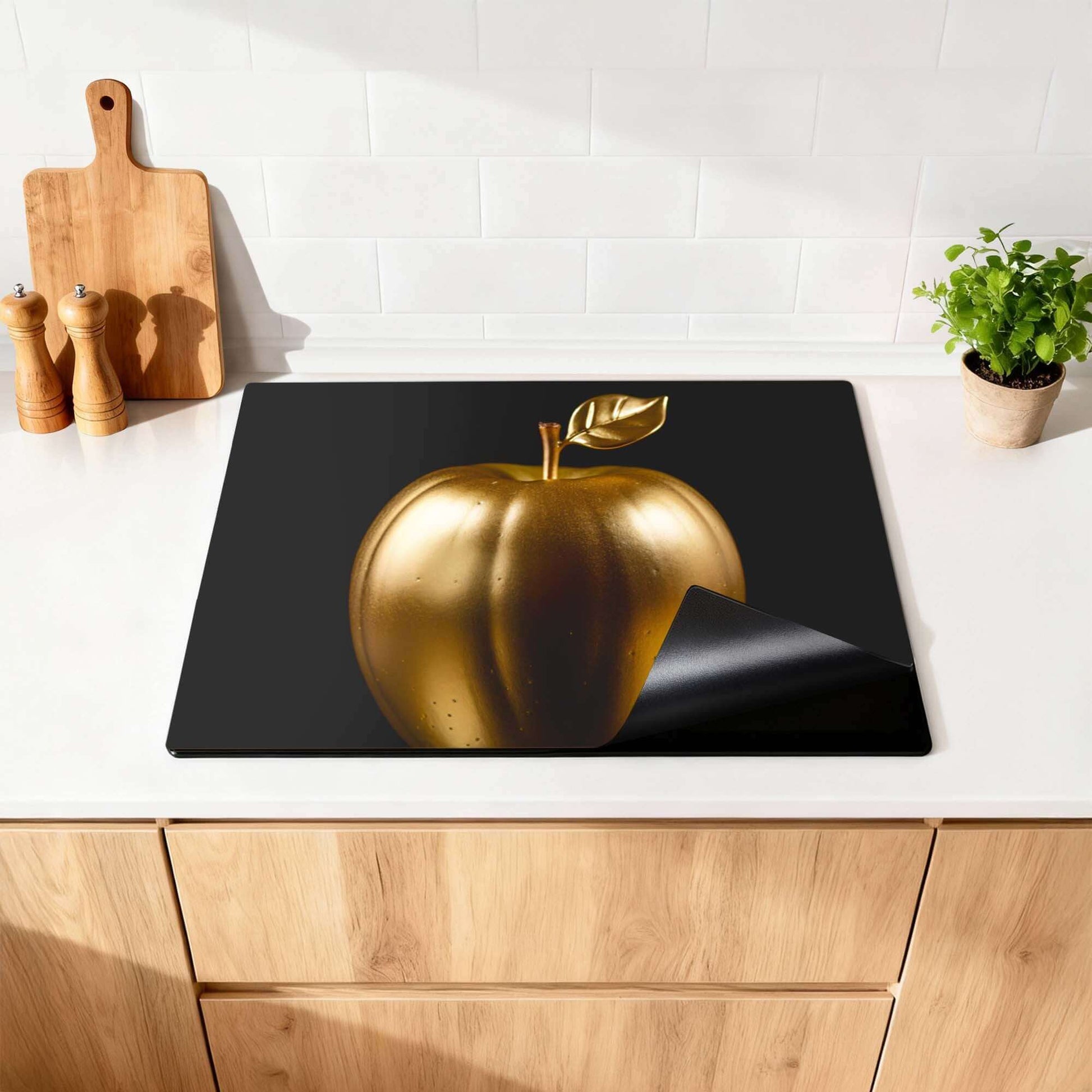 Eve's Edition - Herdabdeckplatte mit einem goldenen Apfel auf einem modernen Küchenhintergrund.