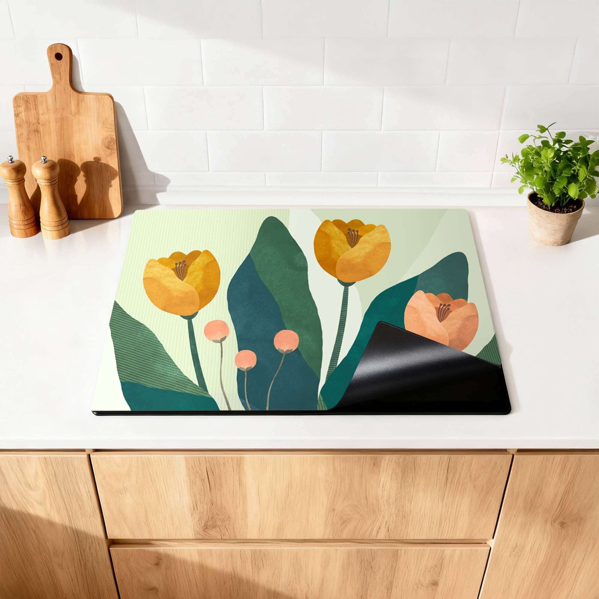 Golden Trio - Herdabdeckplatte mit goldenen Blumen und grünem botanischem Druck auf einem Induktionskochfeld in der Küche