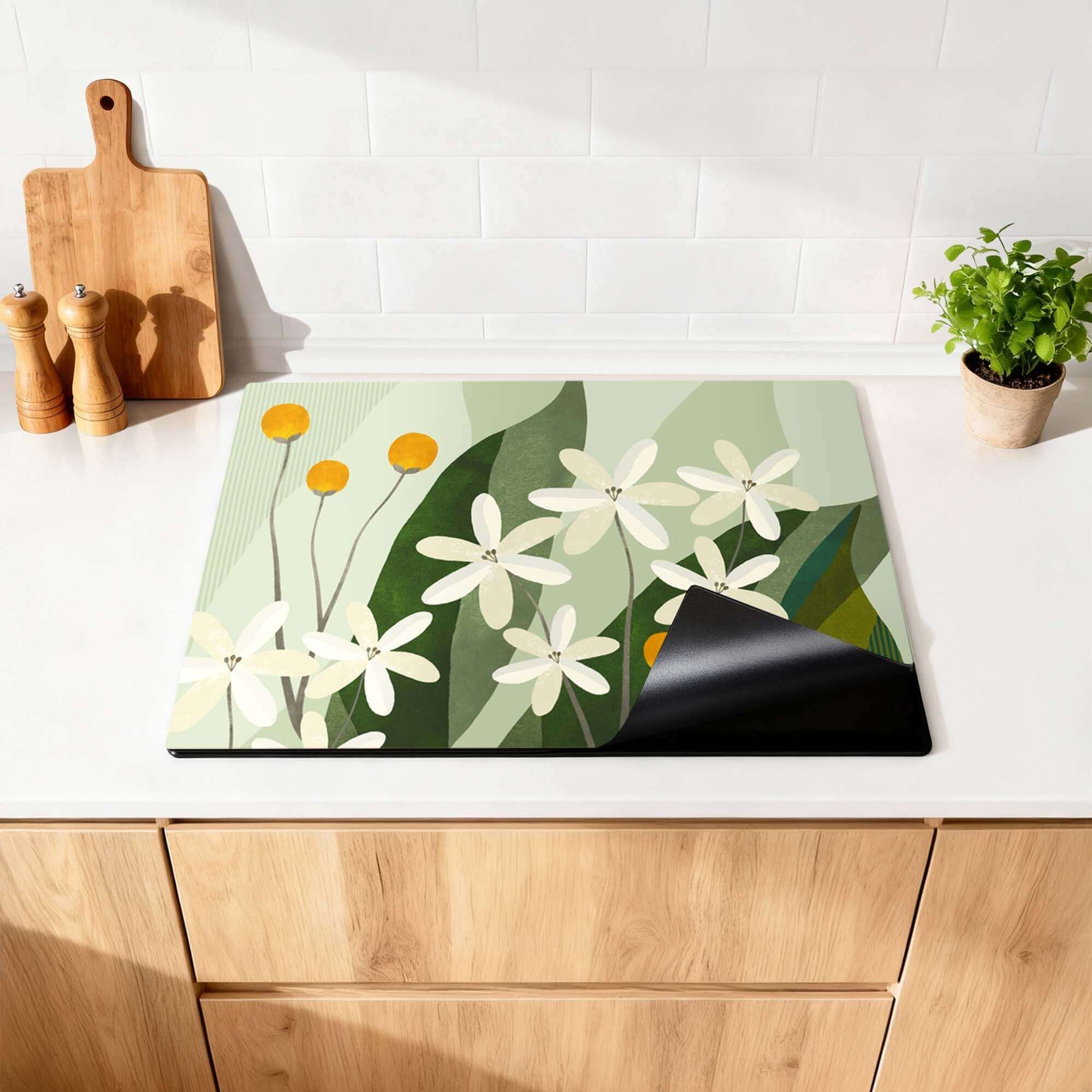 Ivory Spheres - Herdabdeckplatte mit elfenbeinfarbenen Blumen und ockergelben Akzenten auf einer Küchenarbeitsplatte für stilvollen Schutz.