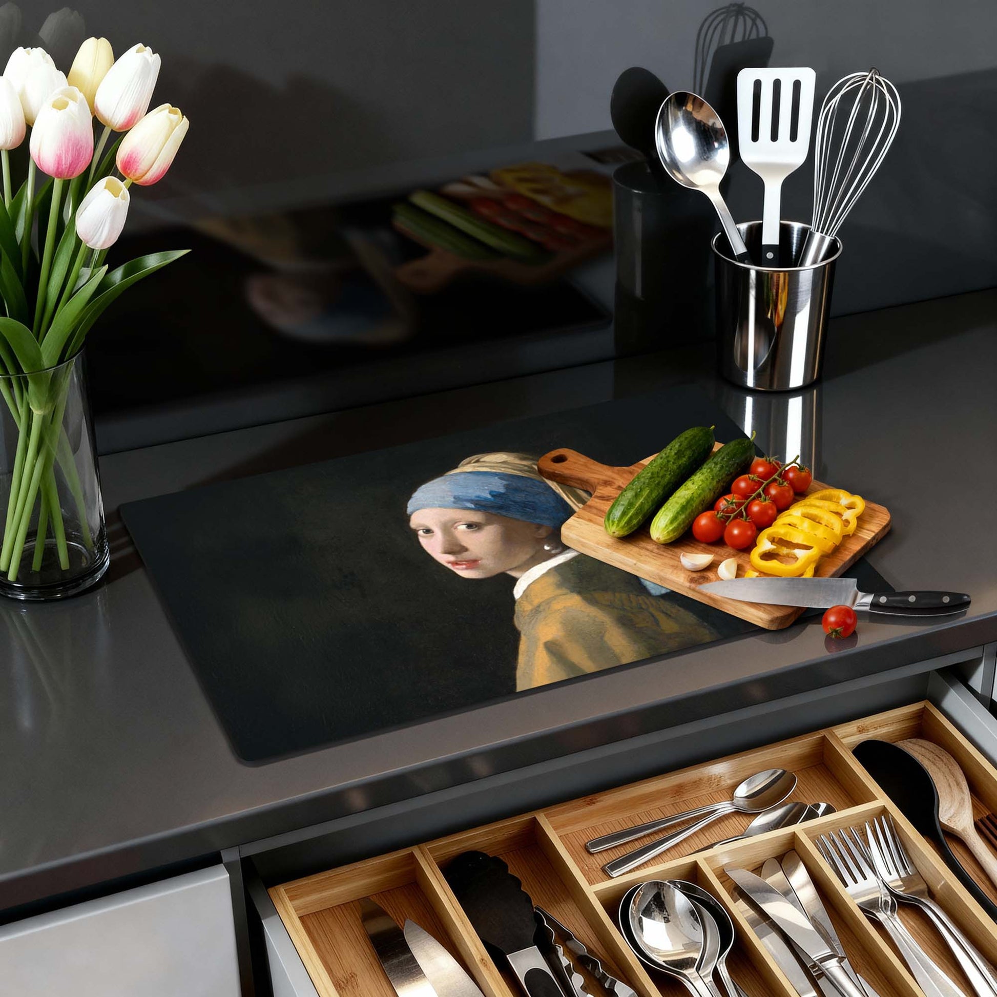 "Das Mädchen mit dem Perlenohrring - Herdabdeckplatte" auf moderner Küchentheke mit Gemüse