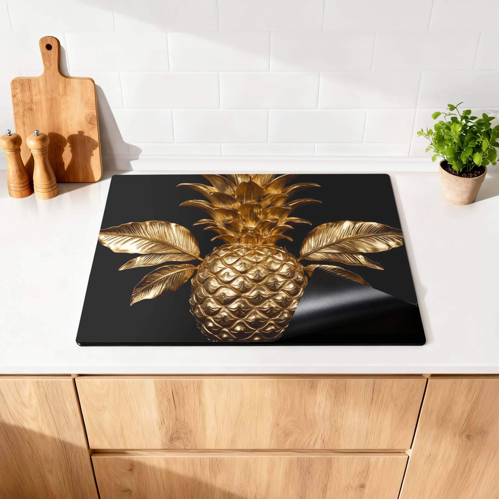 Pine Luxe - Herdabdeckplatte mit goldenem Ananasdesign auf einem modernen Küchenhintergrund.