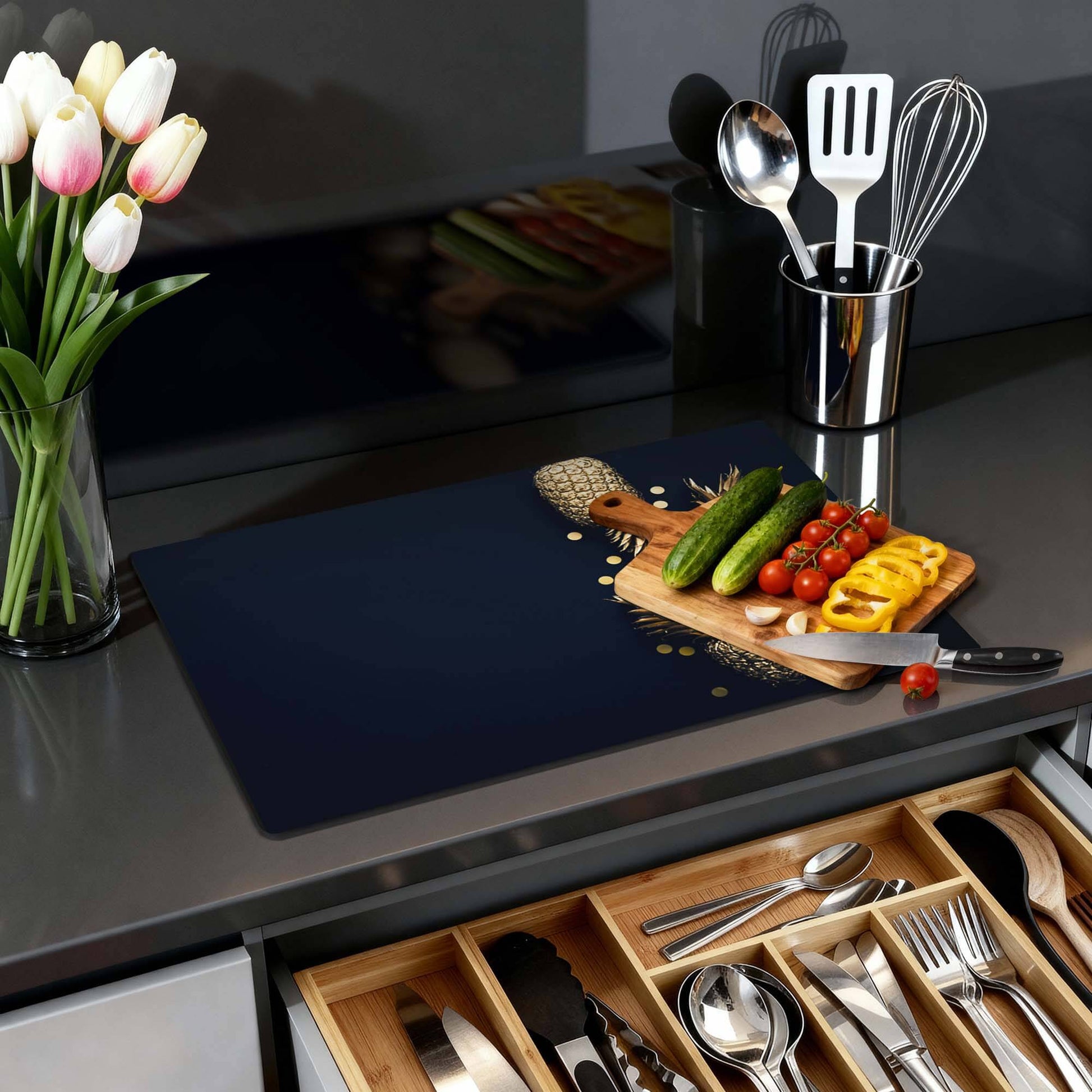 Royal Tropic - Herdabdeckplatte auf einer modernen Arbeitsplatte mit Gemüse und Blumen.