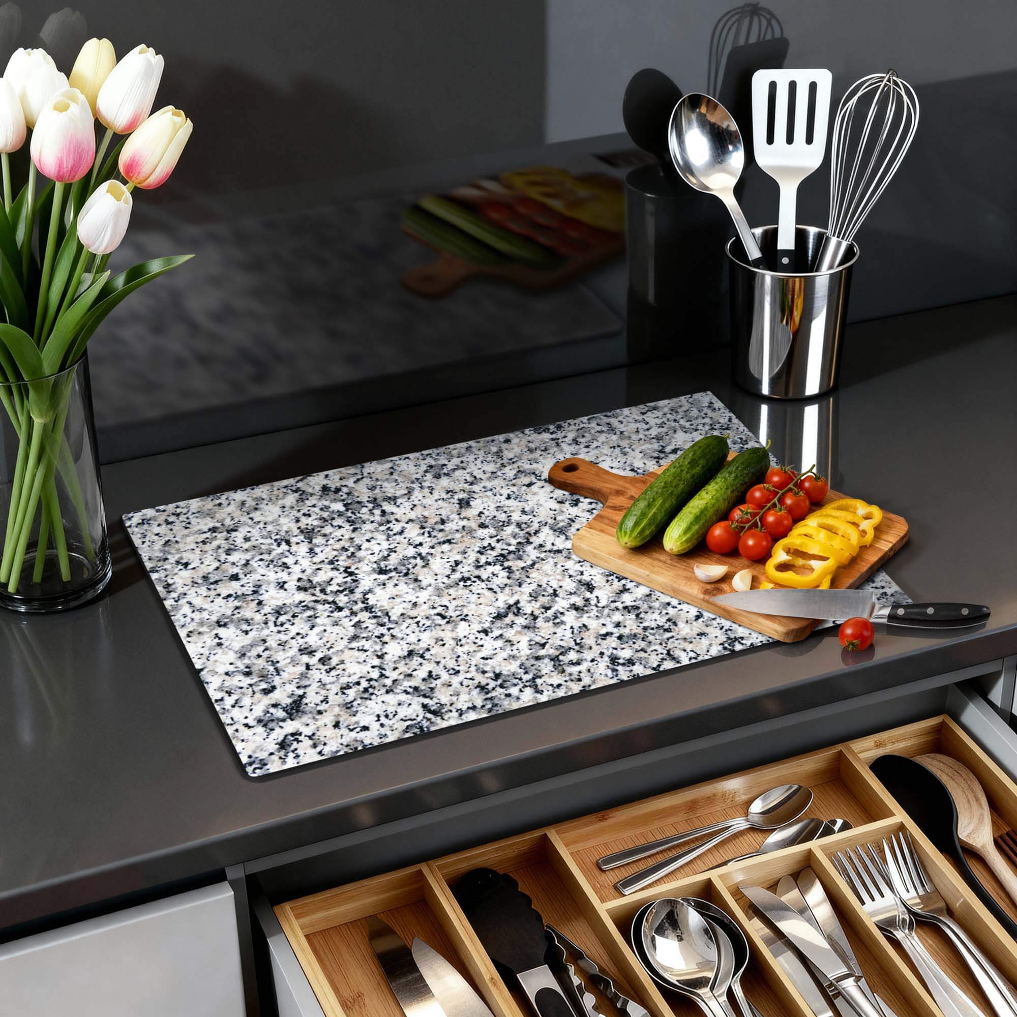 Classic Granite - Herdabdeckplatte auf einer Küchenarbeitsplatte mit Gemüse und Utensilien.