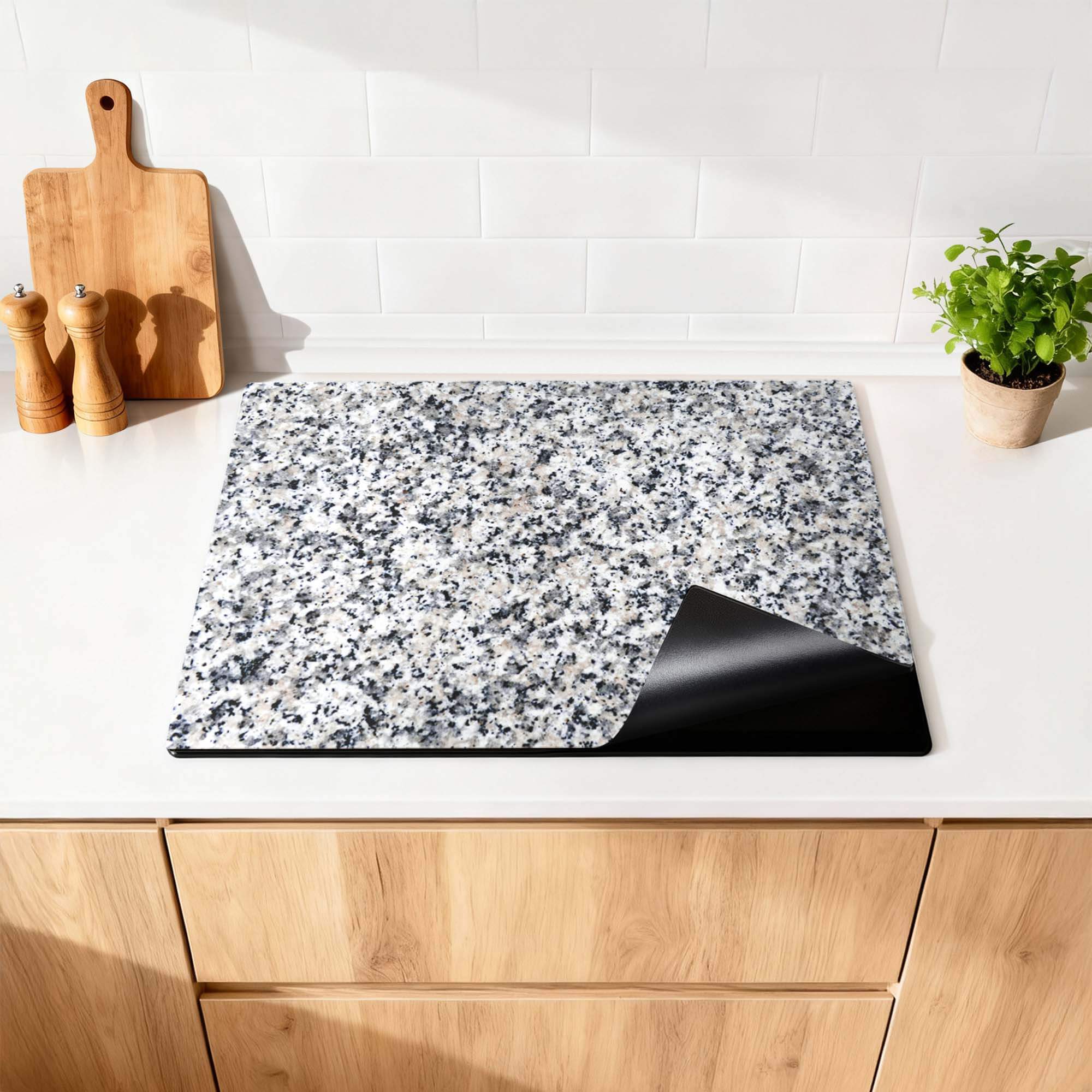 Classic Granite - Herdabdeckplatte auf einer schönen Küchenarbeitsplatte mit Holz und Kräutern.