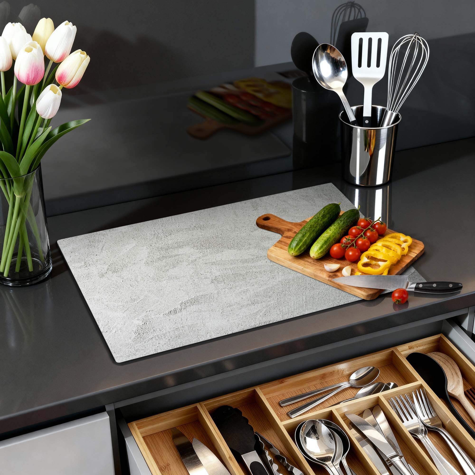 Soft Concrete Finish - Herdabdeckplatte in einer modernen Küche mit Gemüse und Küchenzubehör.