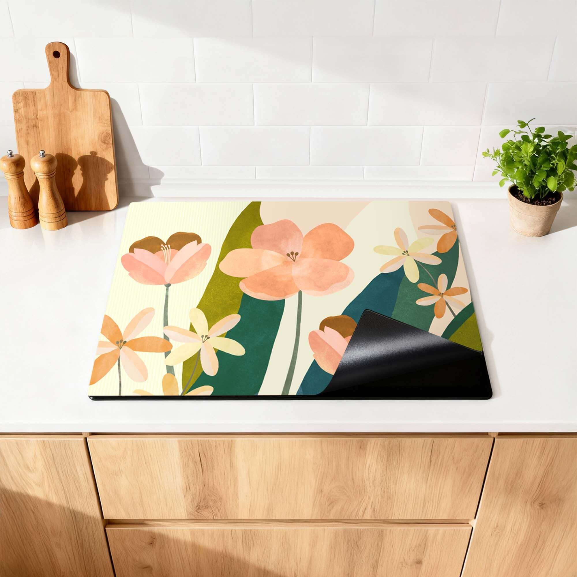 Soft Petals - Herdabdeckplatte mit Pfirsich- und Korallentönen auf einer Küchenarbeitsplatte, elegantes botanisches Design schützt Induktionskochfeld.