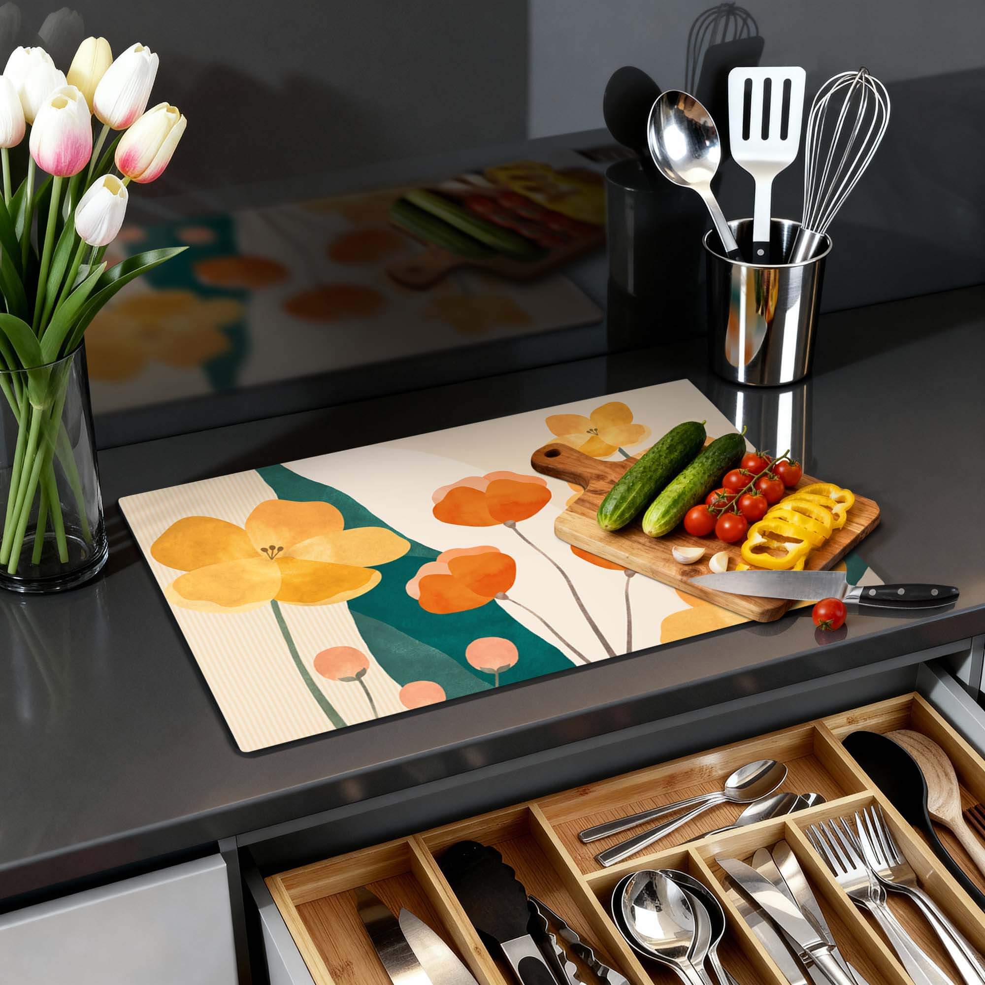 Sunny Field - Herdabdeckplatte mit gelbem und orangefarbenem Blumenmuster auf einer Küchenarbeitsplatte, umgeben von Kochutensilien und Gemüse.