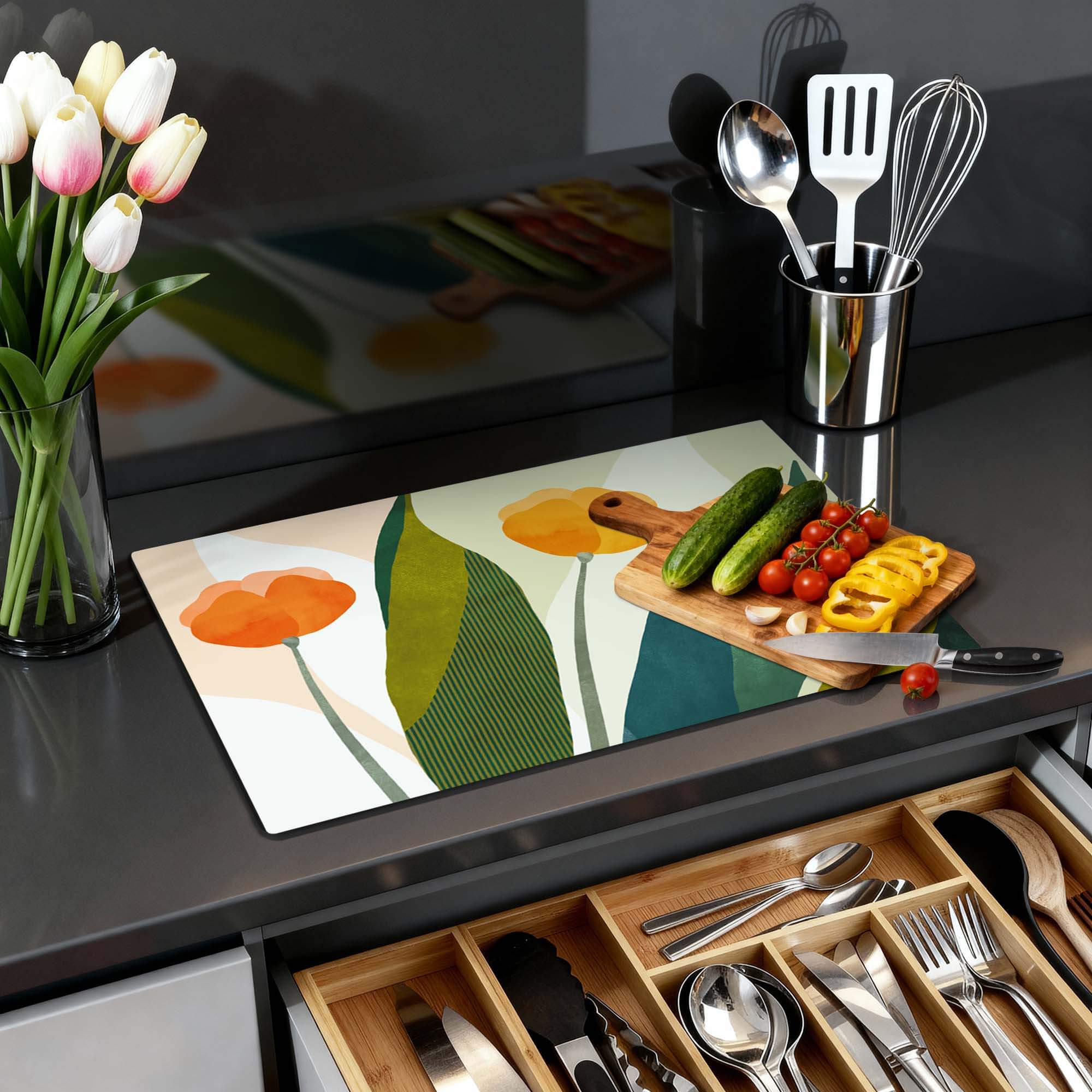 Sunset Blooms - Herdabdeckplatte mit orangefarbenen Blumen und grünen Blättern, Küchenzubehör auf schwarzer Arbeitsplatte mit Gewürzen und Besteckschublade.