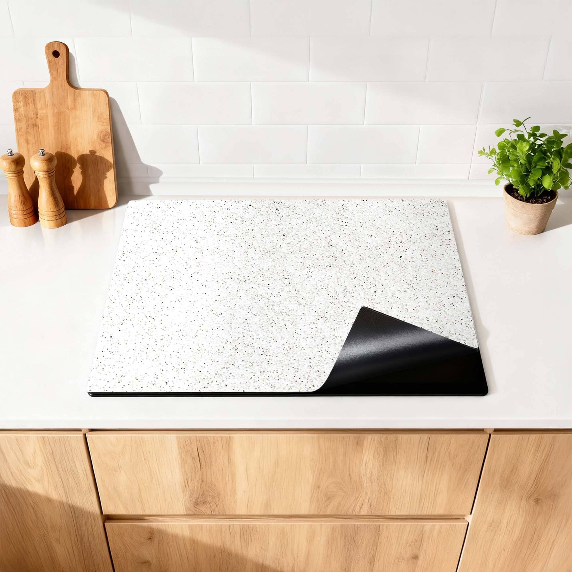 Terrazzo - Herdabdeckplatte auf einer hellen Küchenoberfläche, schützt Induktionskochfelder vor Kratzern und Abnutzung.