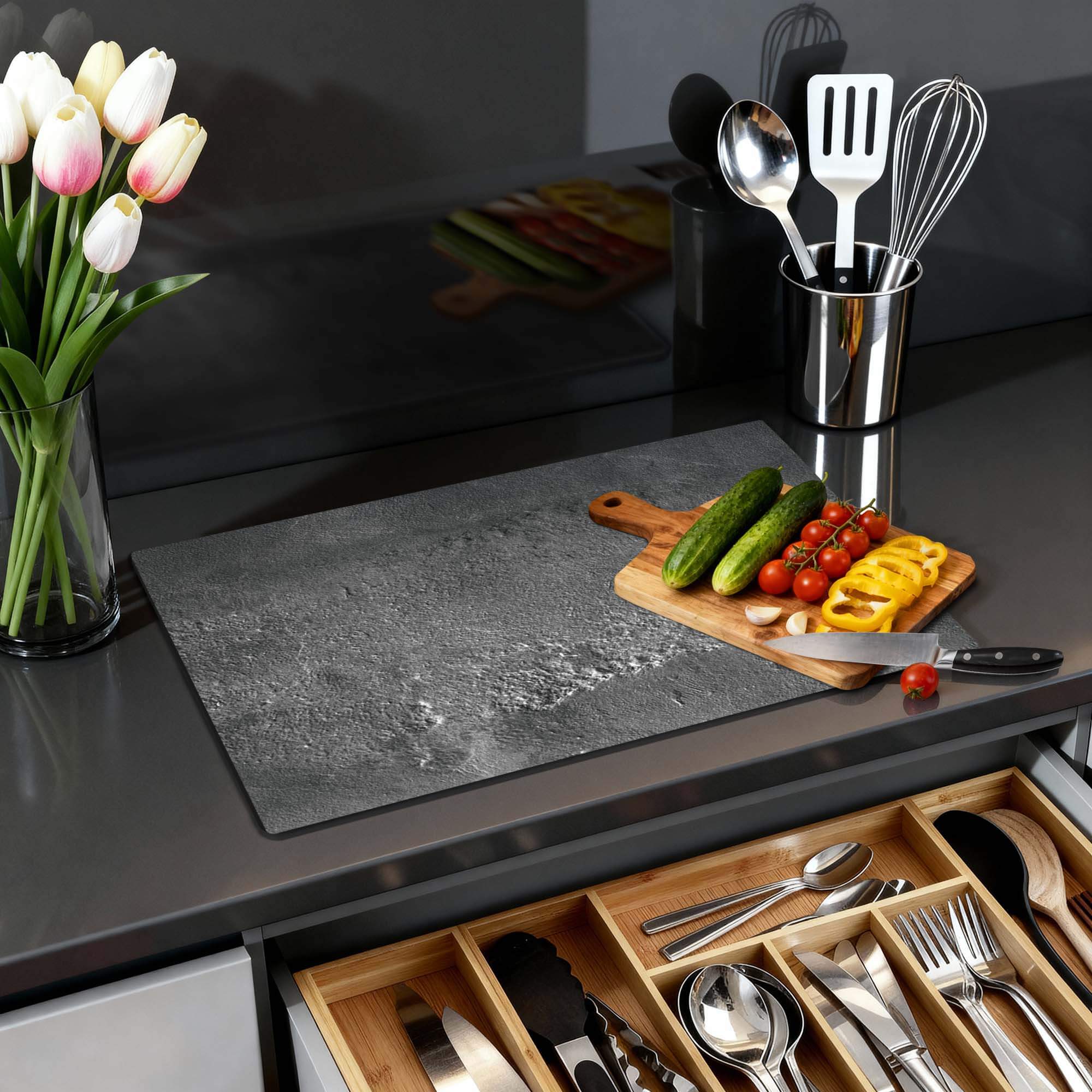 Urban Stone Elegance - Herdabdeckplatte auf einer modernen Küchenarbeitsplatte mit Gemüse und Blumen.