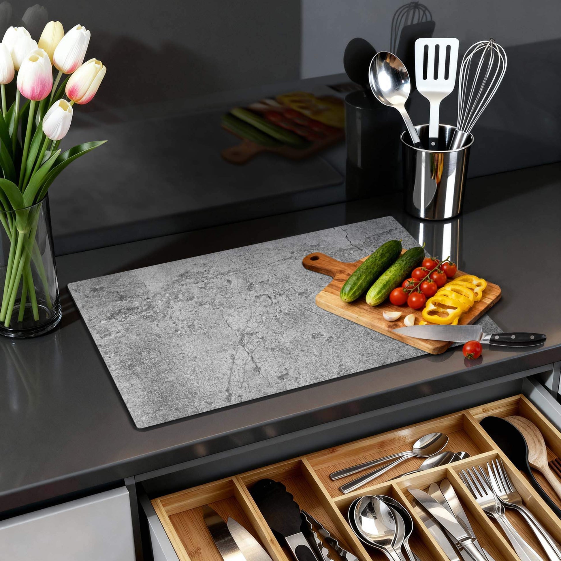 Urban Stone - Herdabdeckplatte auf einer modernen Küchenarbeitsplatte mit Gemüse und Blumen.