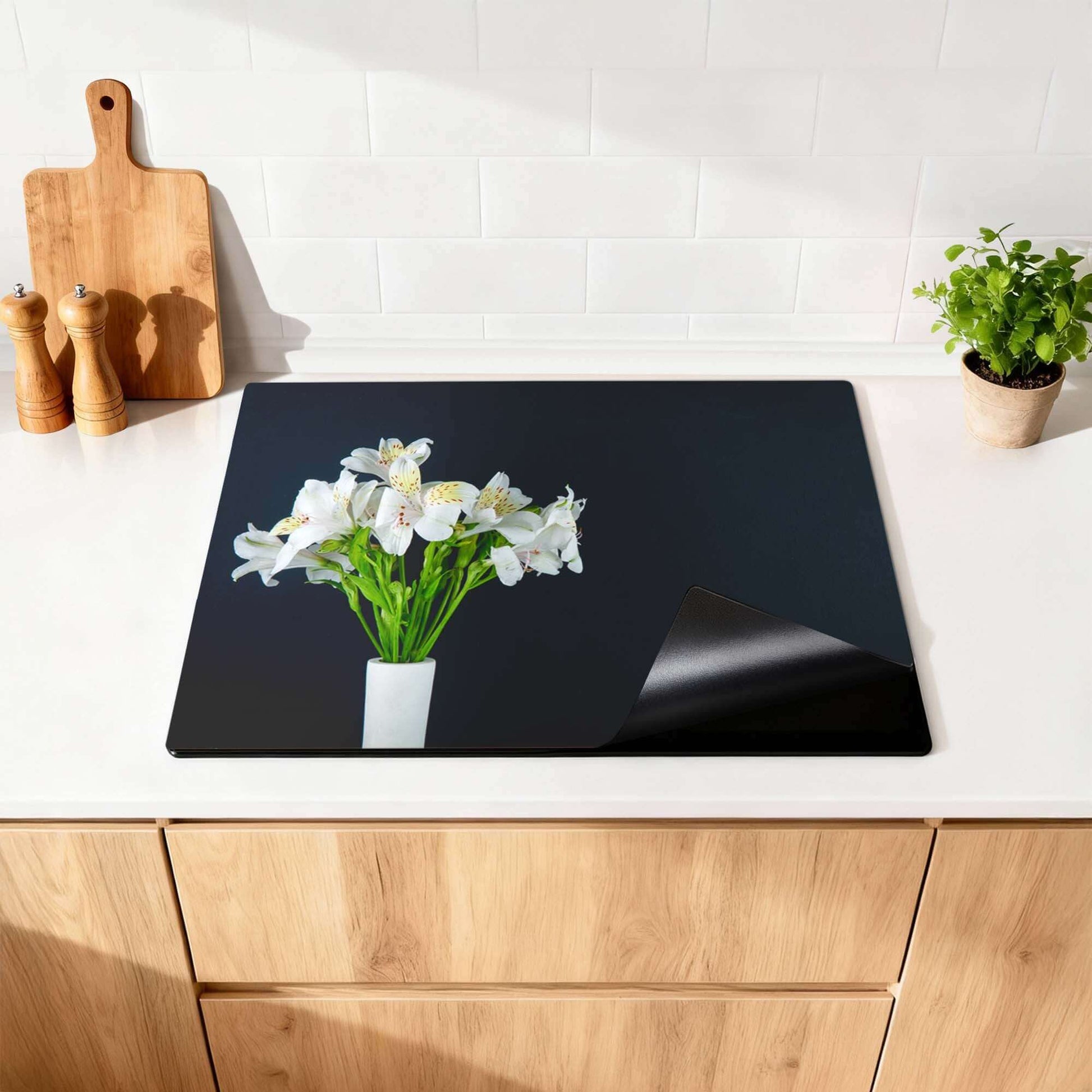 White Whisper - Herdabdeckplatte auf einer Küchenarbeitsplatte mit Blumen und einem sauberen Look.