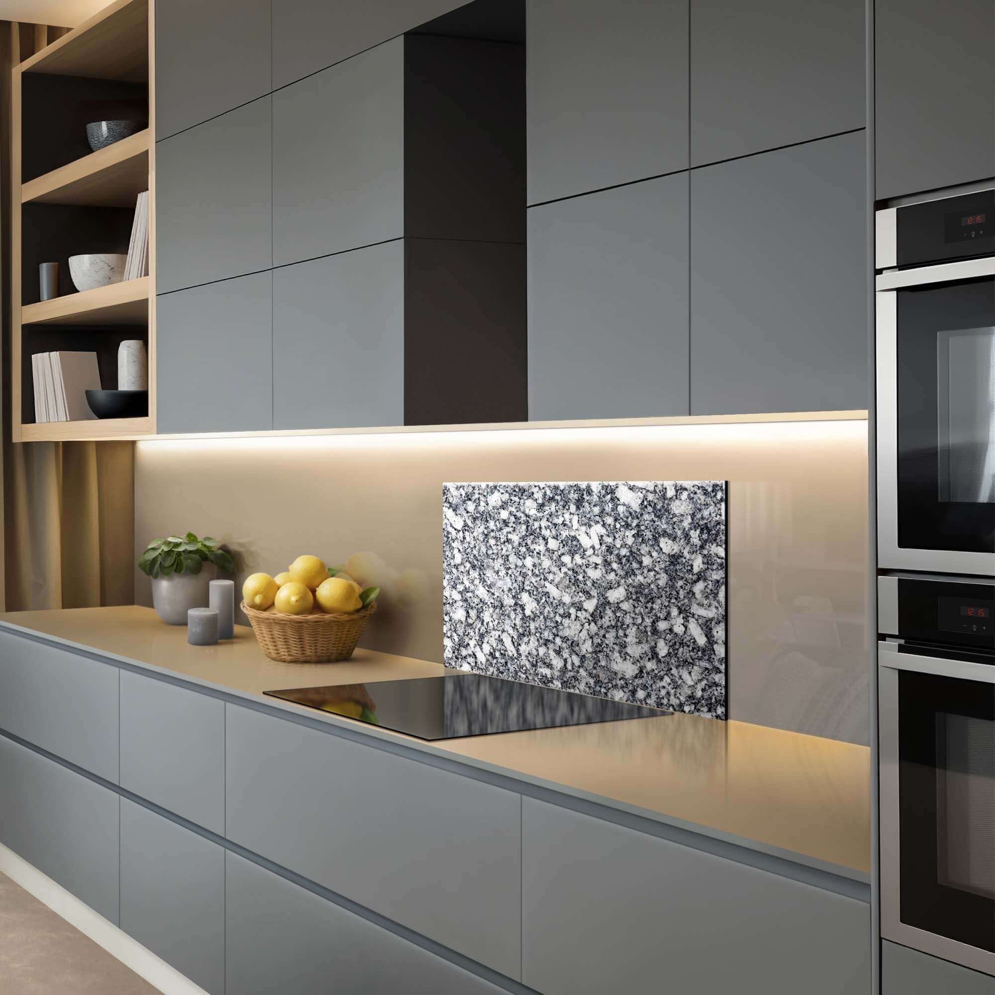 Luxusküche mit Midnight Granite Splashback, einem stilvollen blau-grauen Granit-Splashback auf einer modernen Arbeitsplatte mit Küchenzubehör. Rückwand.